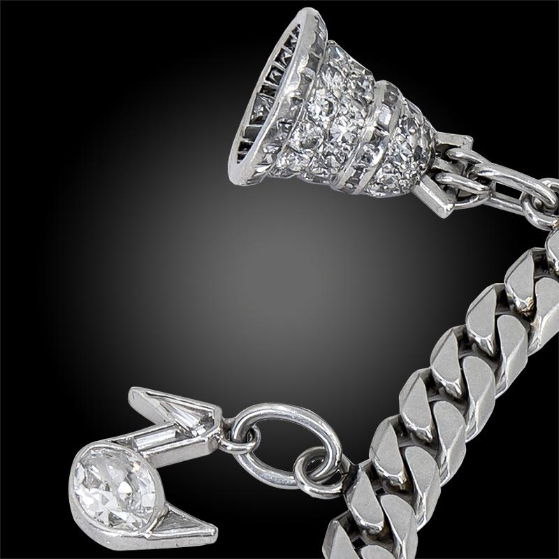 Variously-shaped old-cut diamond-set charms depicting a set of golf clubs – signed Cartier, a bell – signed Van Cleef & Arpels, a duck signed Cartier, a horseshoe – signed Cartier, initials ‘J.G.’ – signed Cartier, a baton – signed Cartier and a