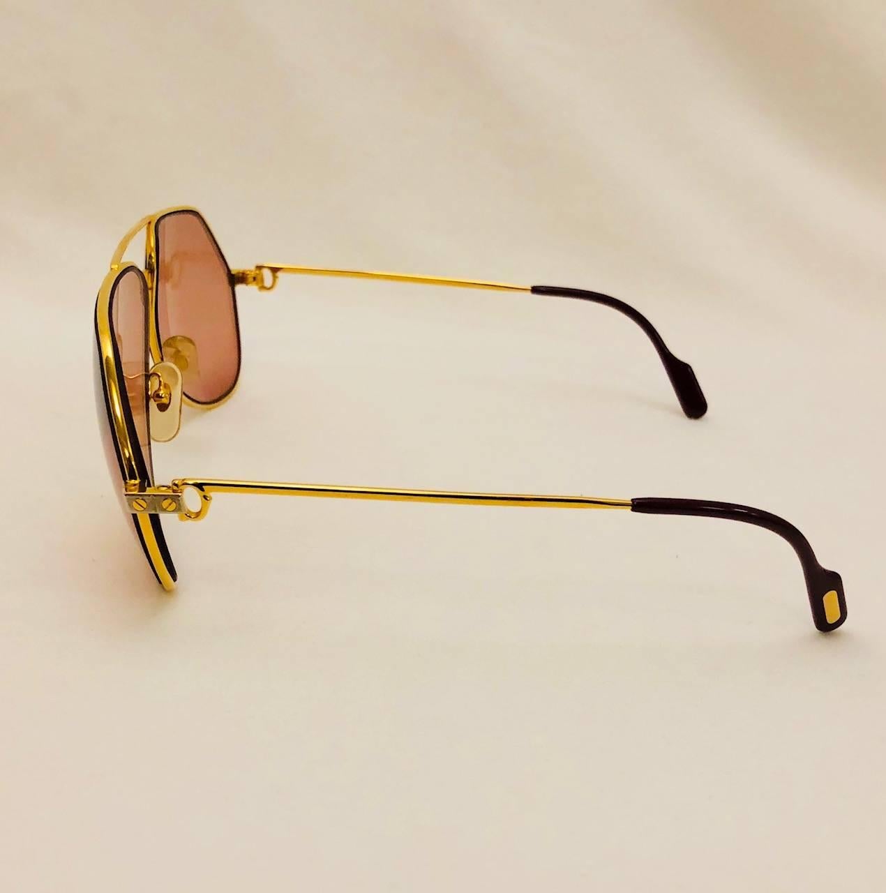 Cartier est réputé pour avoir fabriqué certaines des lunettes de soleil aviateur les plus recherchées au monde !  Ces lunettes de soleil Vintage Vendome Santos Satin sont dotées d'une monture dorée, d'embouts de branches caractéristiques et d'un