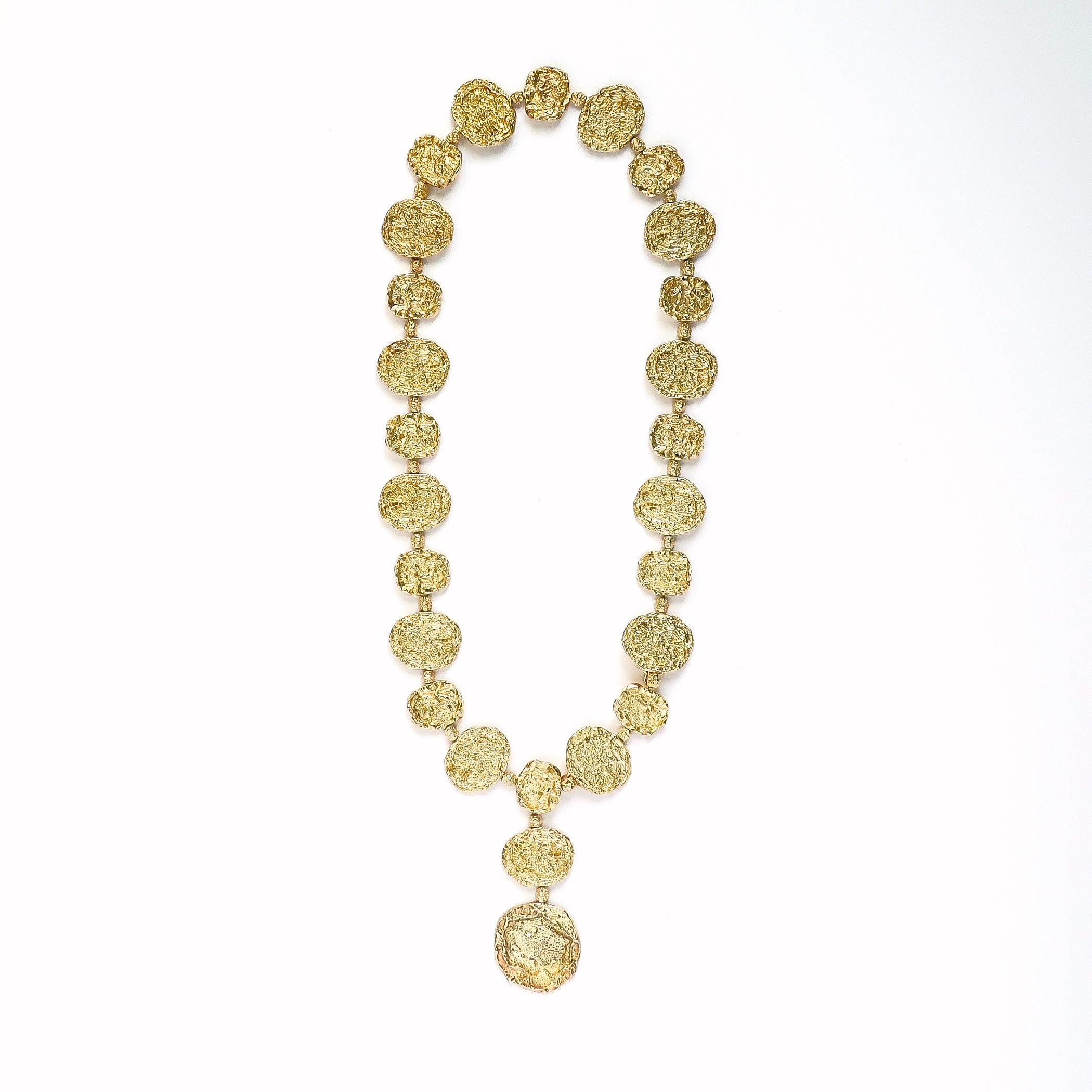 Cartier vermeil (gold on sterling silver) belt comprised of textured circular discs in the brutalist style, designed, circa 1972. Examples of this belt were owned by Jacqueline Kennedy Onassis and Elizabeth Taylor.

This example is longer than