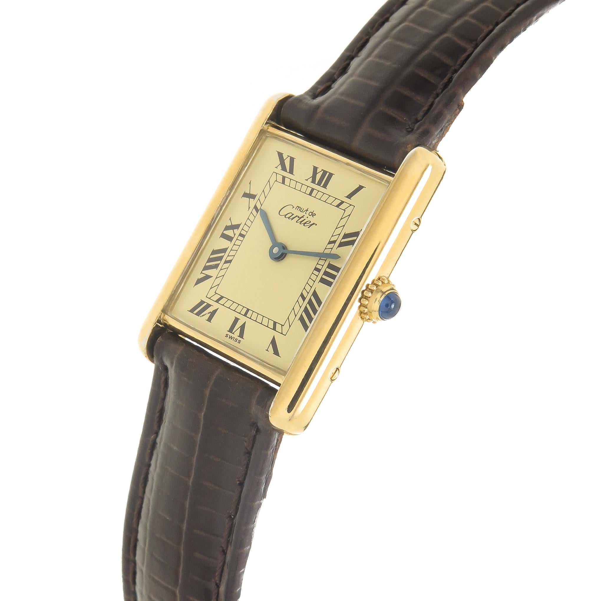 Circa 1990 Cartier Must De Cartier Standard Size Classic Tank Wrist Watch, 30 X 24 MM Vermeil ( Gold plate on Sterling Silver ) 2 Piece case.  Cream dial with Black Roman Numerals, quartz movement, sapphire crown. New Hadly Roma Brown padded Leather