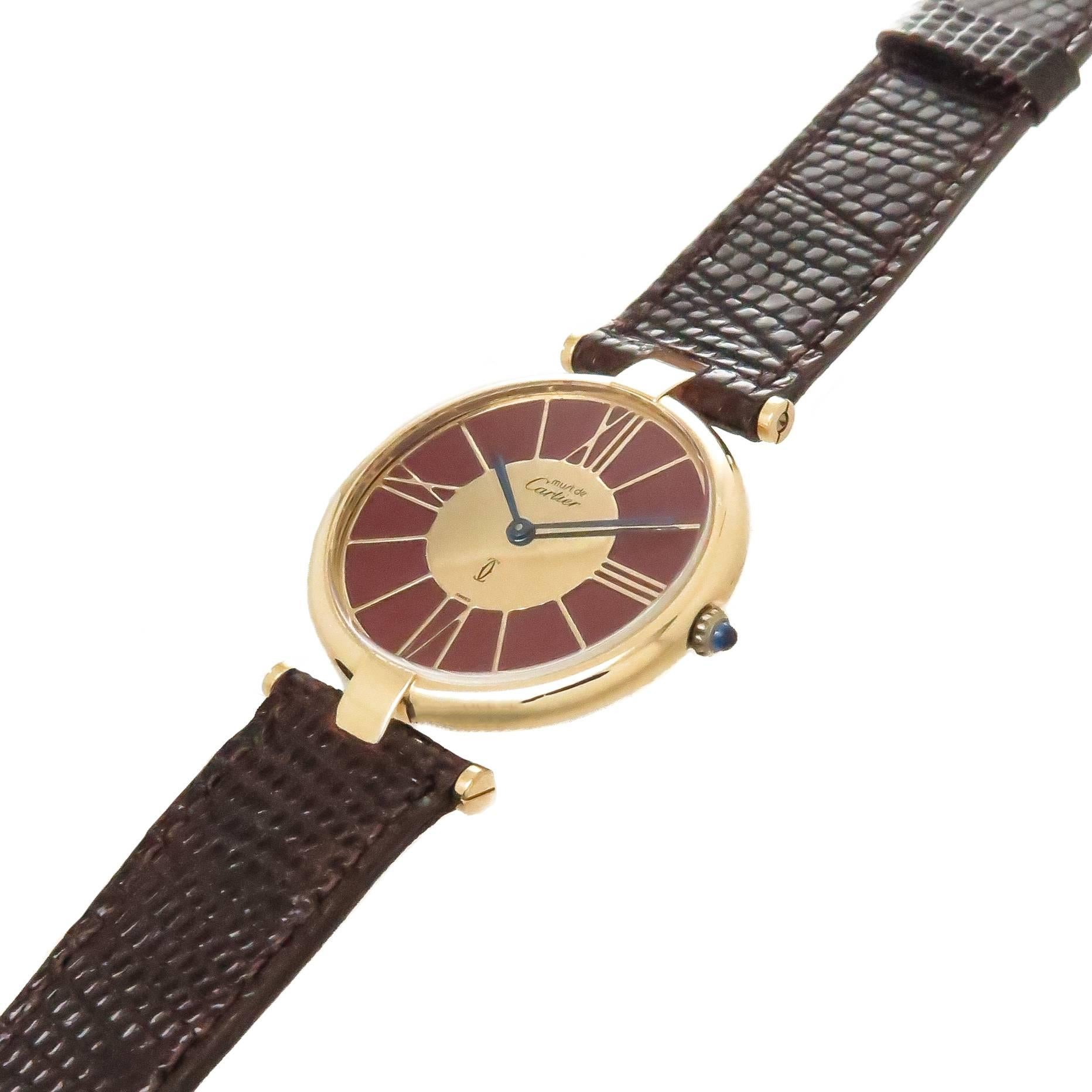 Circa 1990s Cartier Vendome Vermeil ( Gold plate on Sterling Silver ) Wrist Watch. 30 MM 2 piece case, unusual Burgundy and Gold Dial, Quartz movement, Sapphire Crown. New Burgundy Lizard Strap and original Cartier Gold Plate Tang buckle, watch