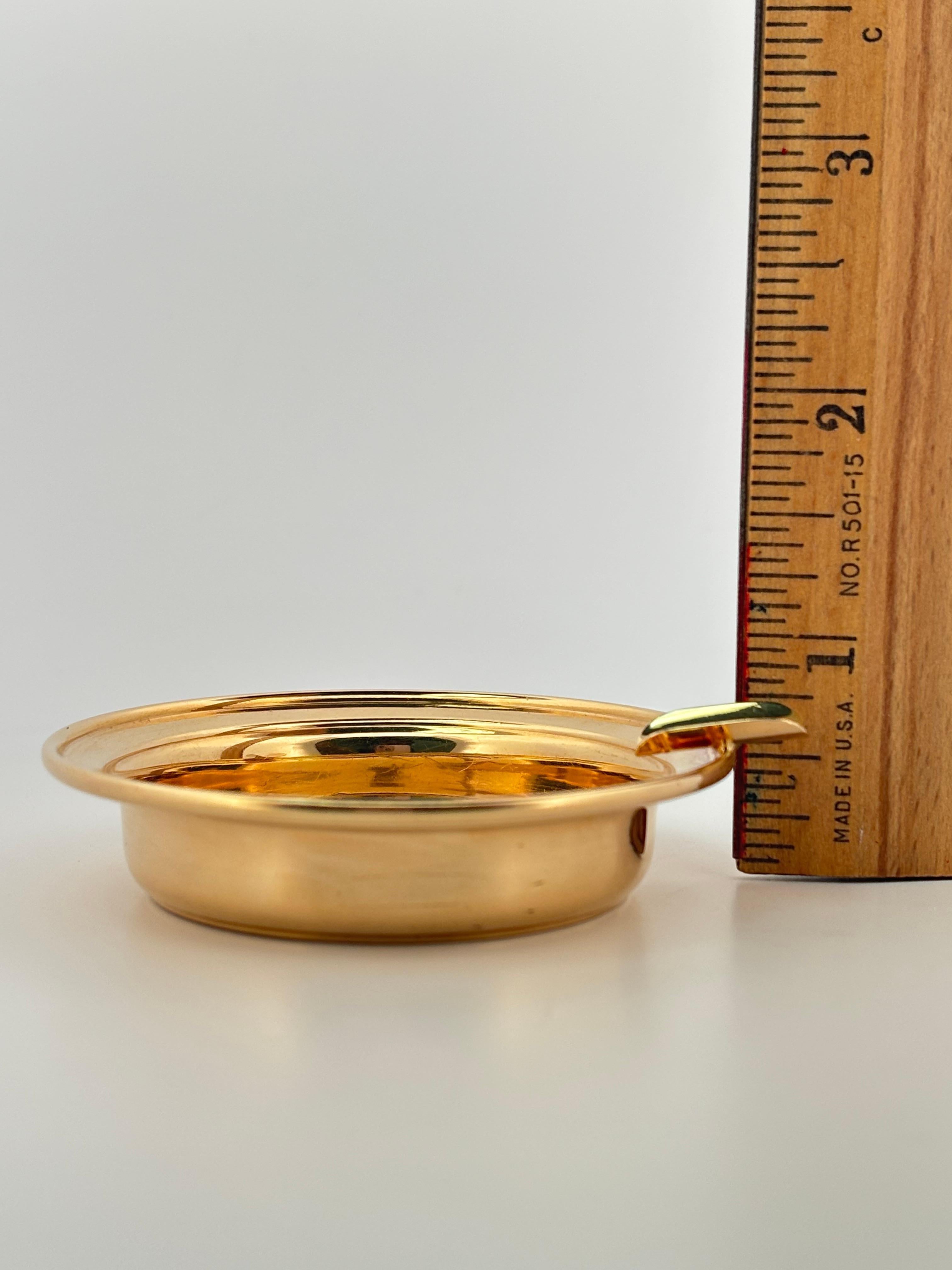 This exquisite Cartier ashtray is a rare example of refined luxury design, crafted in solid 14k yellow gold. Weighing 21.0 grams and measuring 2.5 inches in diameter, it combines elegance and functionality in a timeless form. The circular dish