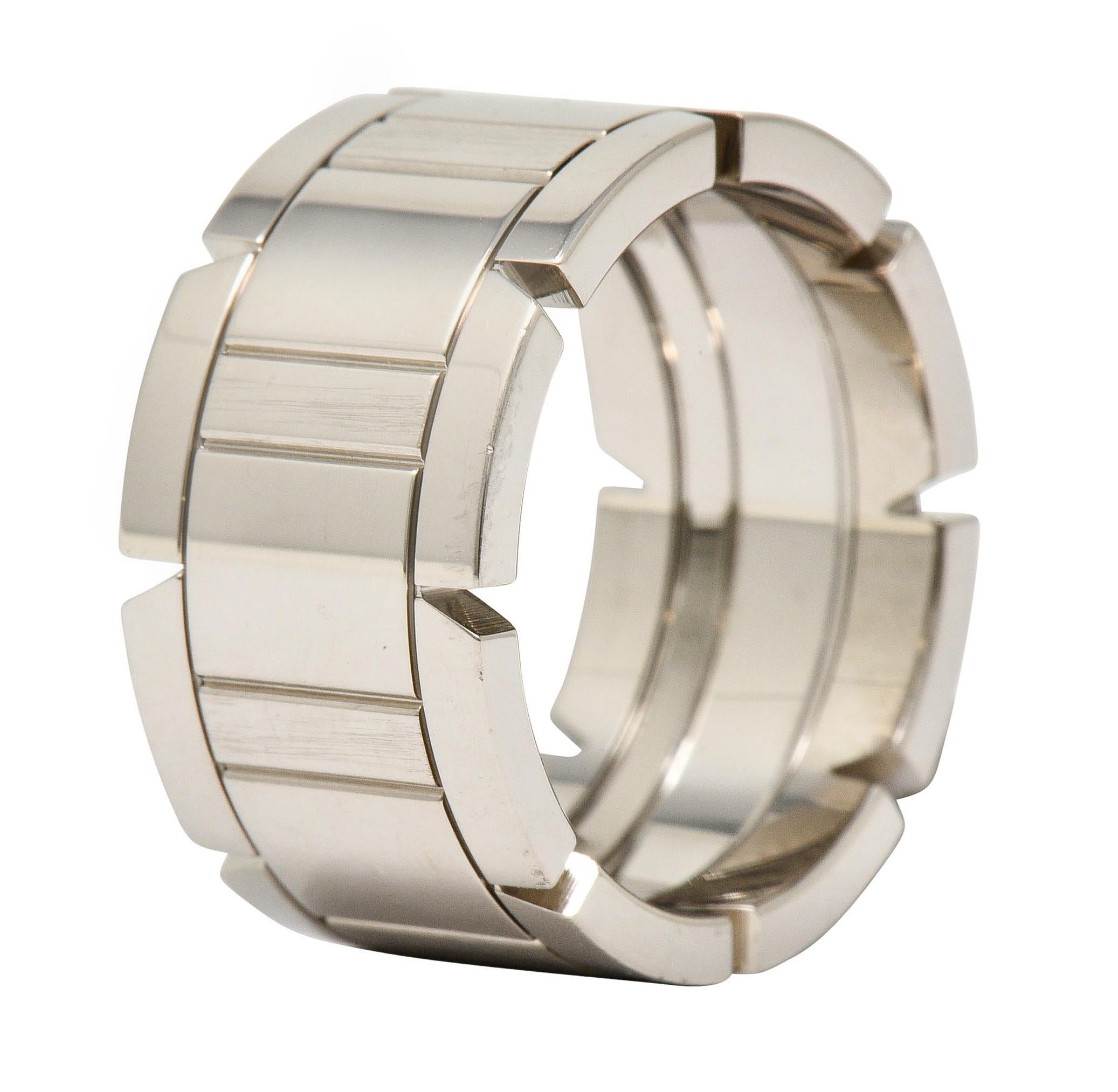 Wide band ring features a deeply engraved center depicting wide and narrow rectangles

Flanked by polished white gold edges with a pierced triangular motif

Numbered and fully signed Cartier with French maker's mark

Stamped 750 for 18 karat