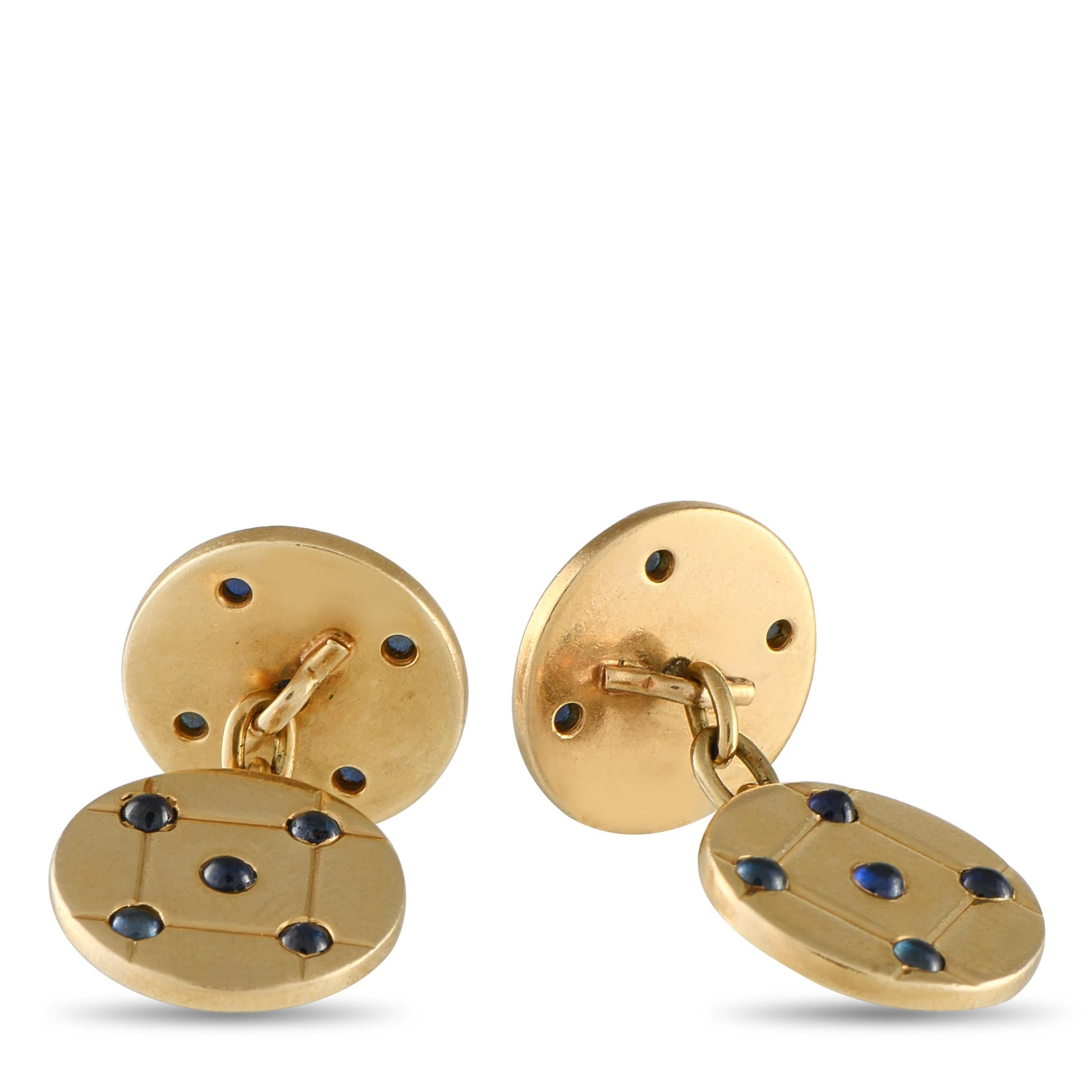 Chiudi i polsini con stile con questa coppia di gemelli a catena di Cartier. Sono caratterizzati da sottili dischi in oro giallo decorati con un motivo trapuntato e punteggiati da zaffiri cabochon. Il connettore a catena facilita il fissaggio