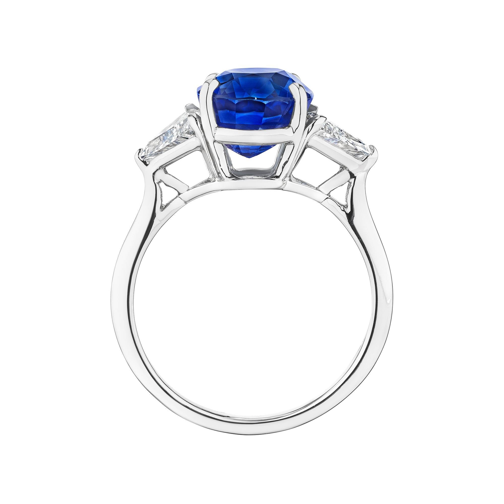 As exhilarating as a velvety midnight blue sky, this Cartier sapphire and diamond ring is mesmerizing.  With an 4.67 oval cut AGL certified center natural sapphire and trillion side diamonds, this handmade platinum ring is a one-of-a-kind
