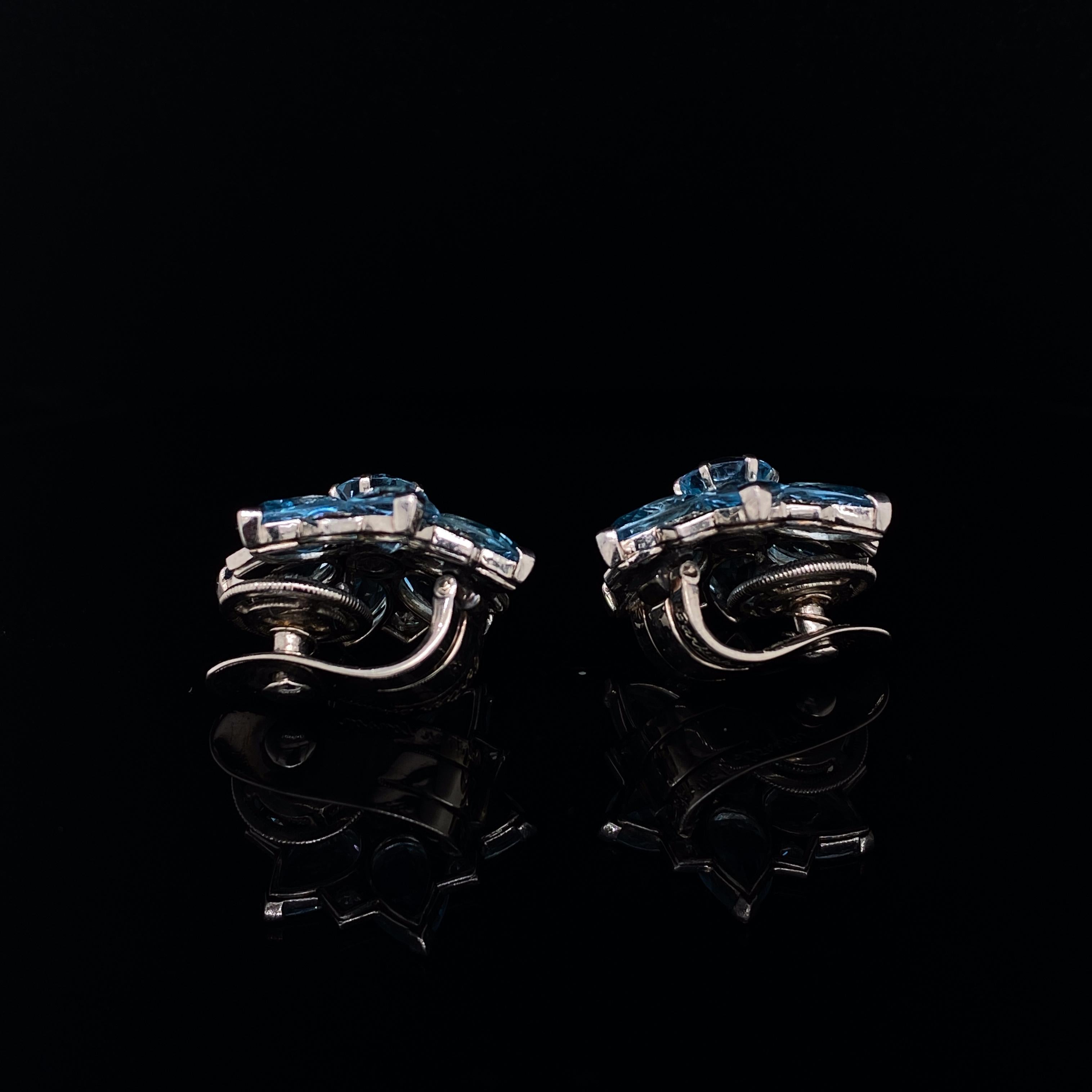 A pair of Cartier London vintage aquamarine and diamond floral platinum earrings, circa 1940.

Each clip of stylised floral design is set with pear cut aquamarine petals with a round cut aquamarine centre inter-spaced with collet set diamond