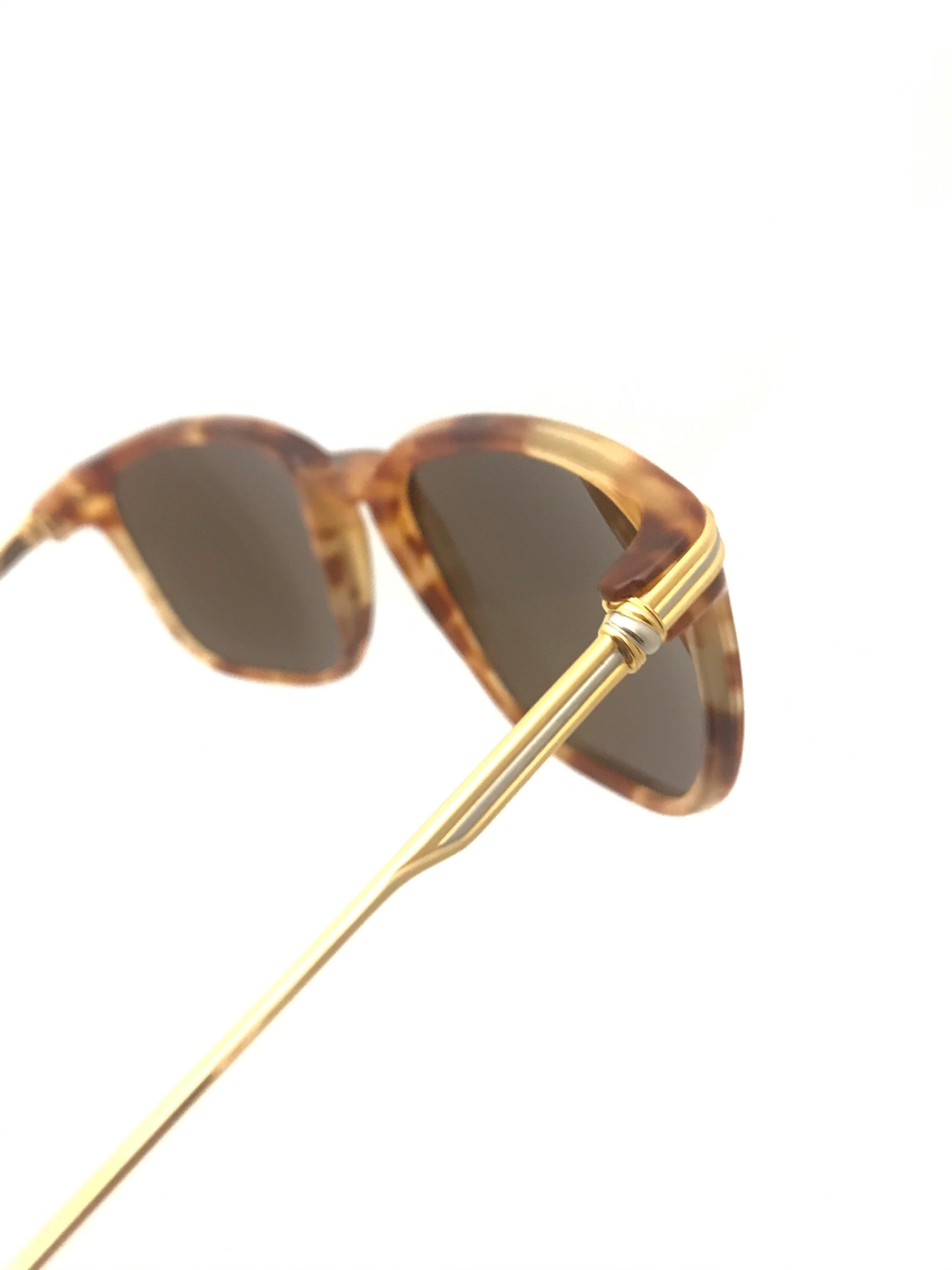 Vintage gold plated sunglasses from Cartier. Soft squared shape. Brown tint on the lens. Light tortoise shell frames, gold plated legs and tortoise shell tips. Branded 'Cartier' gold plaque at the end of each tip. Dimensions: Across the bridge: