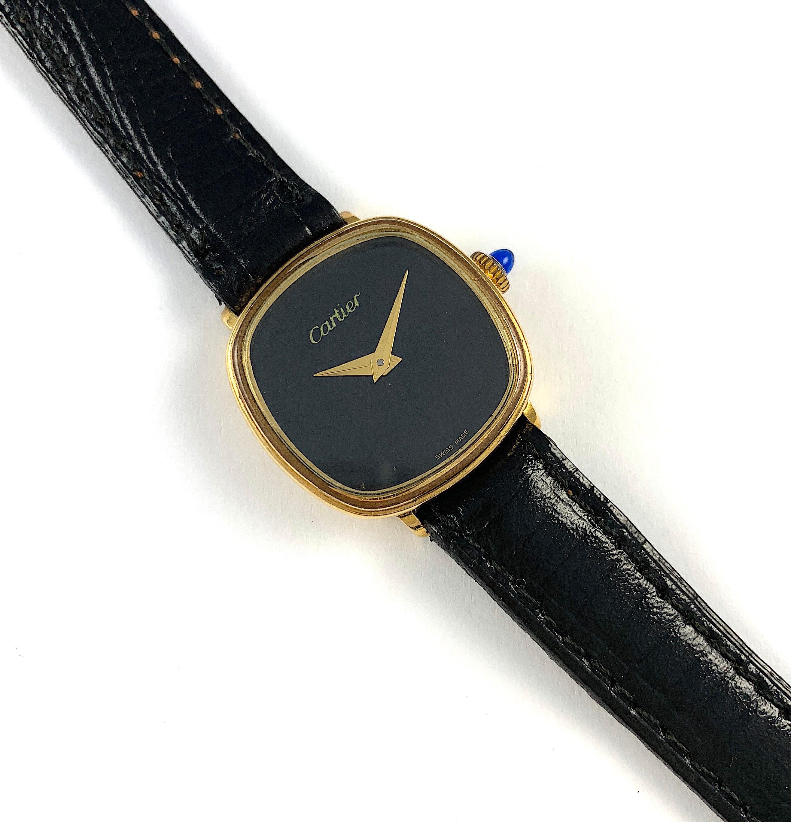 Cartier Cushion Shaped Manual Wind Electroplated Watch
Black Onyx Swiss Made Cartier Dial
Manual Wind Movement
18K Gold Electroplated Signed Cartier Case
Blue Cabochon Crown
Generic Black Strap
Approximately 24mm x 24mm
Some Light Fading of Gold