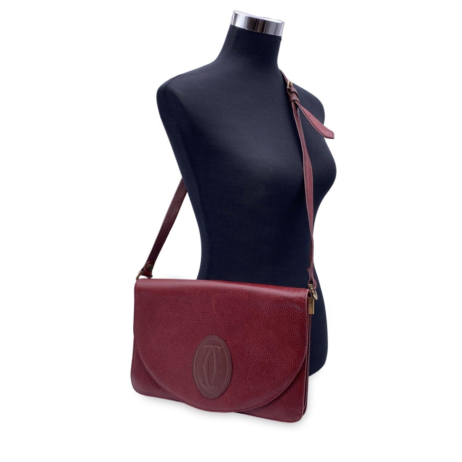 This beautiful Bag will come with a Certificate of Authenticity provided by Entrupy. The certificate will be provided at no further cost CARTIER Paris Vintage shoulder bag in Burgundy genuine leather. Flap with magnetic button closure. Cartier logo