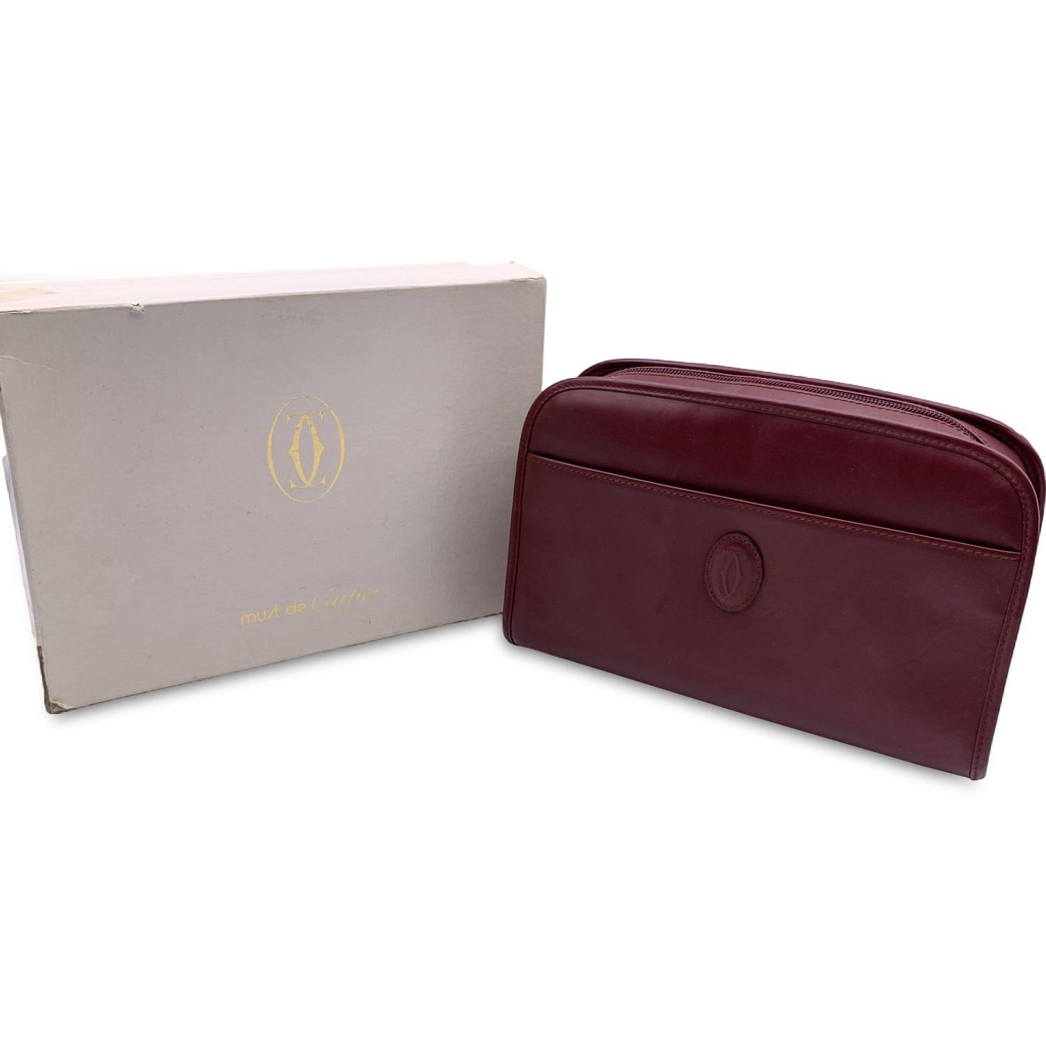 Cartier vintage burgundy leather pochette cosmetic bag. Burgundy leathe. CC - Cartier logo patch on the front. front open pocket. Upper zipper closure. Fabric lining. 2 elasticated pockets inside. 'Must de Cartier' tag inside


Condition

B - VERY