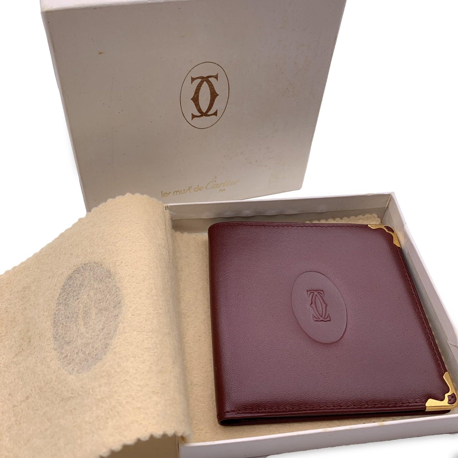 Vintage Cartier wallet in burgundy leather. Bifold design. 1 bill compartment, 1 slot for a checkbook. Cartier logo embossed on the front. Leather lined. 'Cartier Paris' embossed inside. Details MATERIAL: Leather COLOR: Burgundy MODEL: - GENDER: