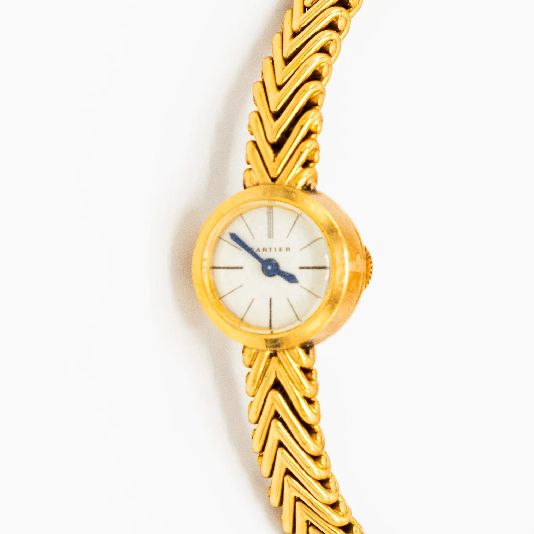 Dieser seltene Cartier-Zeitmesser aus den 1950er Jahren ist aus 18 Karat Gelbgold gefertigt und verfügt über ein wunderschön strukturiertes Armband mit Chevron-Muster. Das ovale Gehäuse misst etwa 1,3 cm in der Breite und 2,4 cm in der Länge und