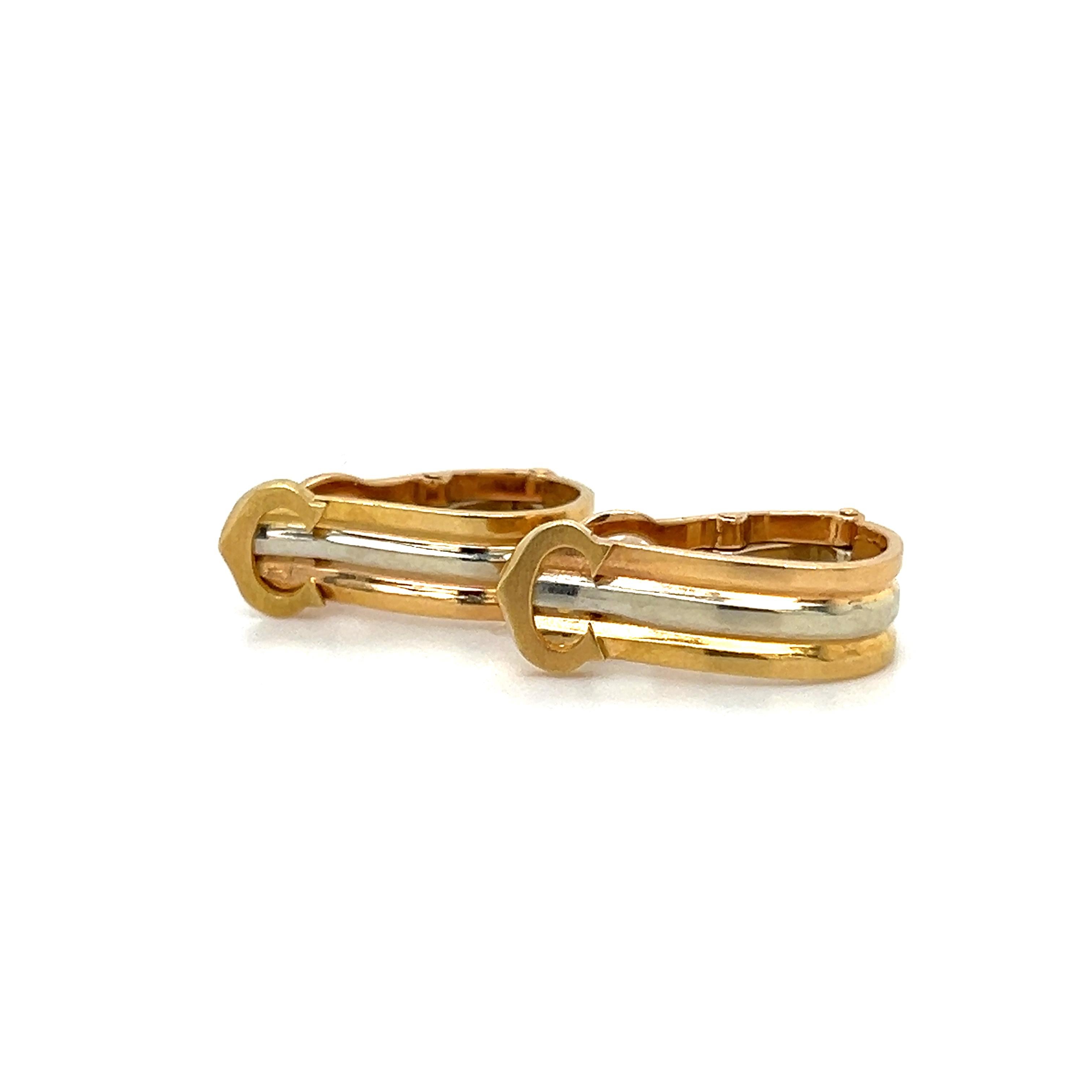 Elegant pair of vintage Cartier huggie style hoop earrings. The pair are from the trinity collection as they display a tri color gold finish. the pair is highlighted with the Cartier iconic 