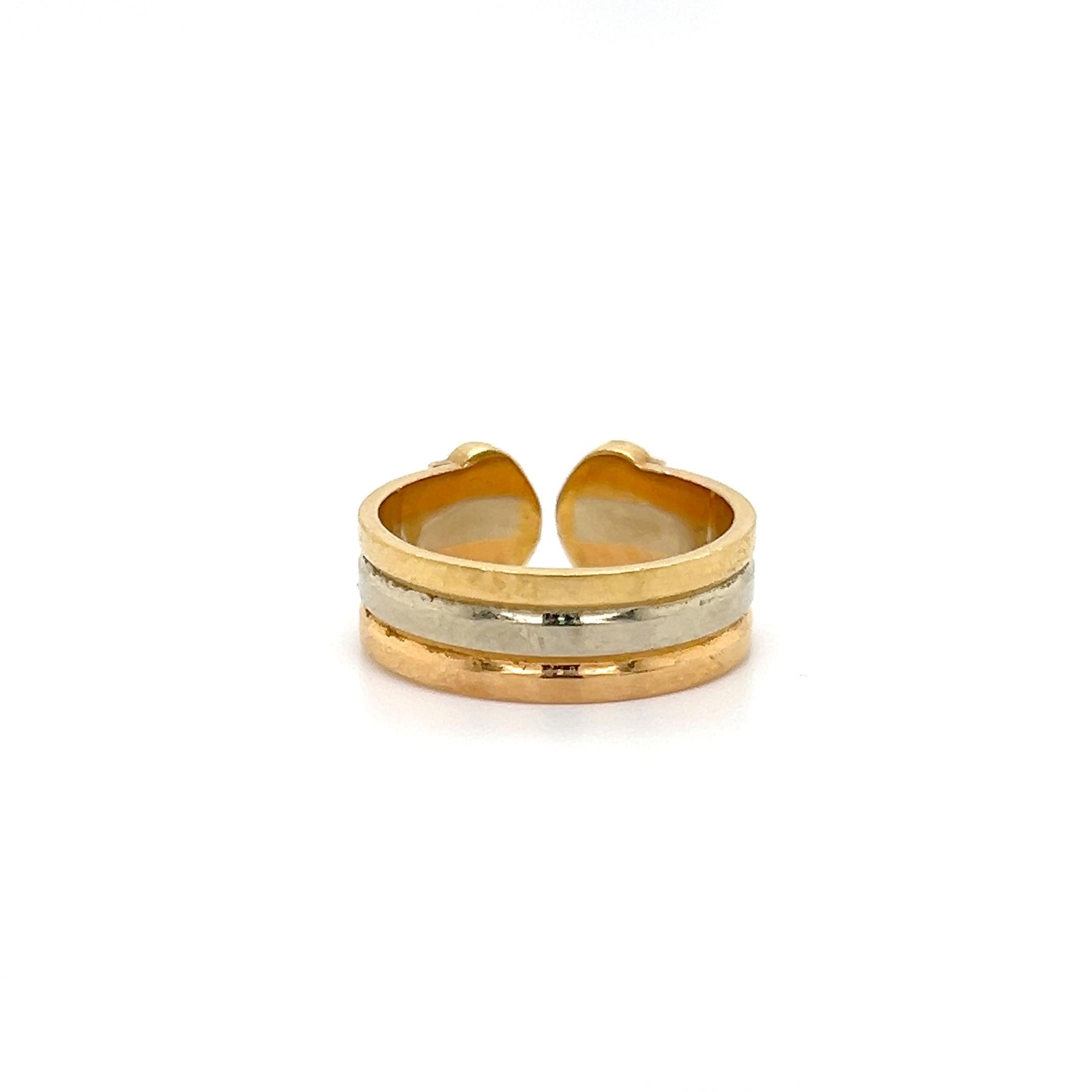 Timeless design by famed designer Cartier. The ring is crafted in 18k gold with a tri color design. Rows of yellow, white and rose gold lead to an open work double C design. The ring is a size 48 or 4.5, the ring is fully hallmarked by the designer