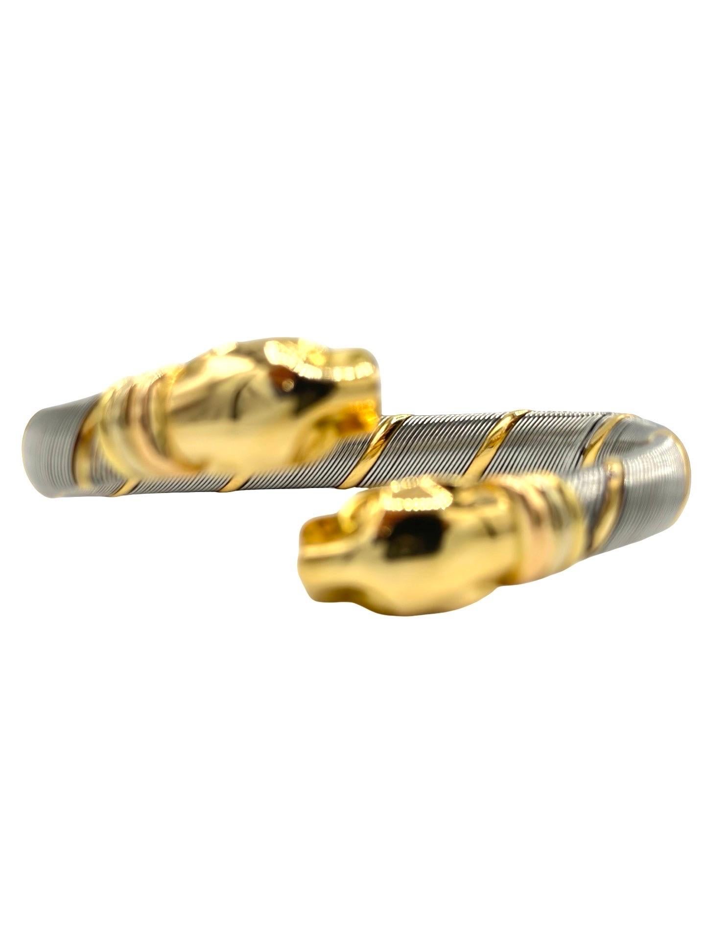 Bracciale Bangle Cartier Double Panther Head Bypass finemente realizzato in oro giallo e bianco a 18 carati.  Fili di oro bianco e giallo si fondono per creare toni caldi e ricchi, contrastando con dettagli in oro bianco lucidato, culminando in
