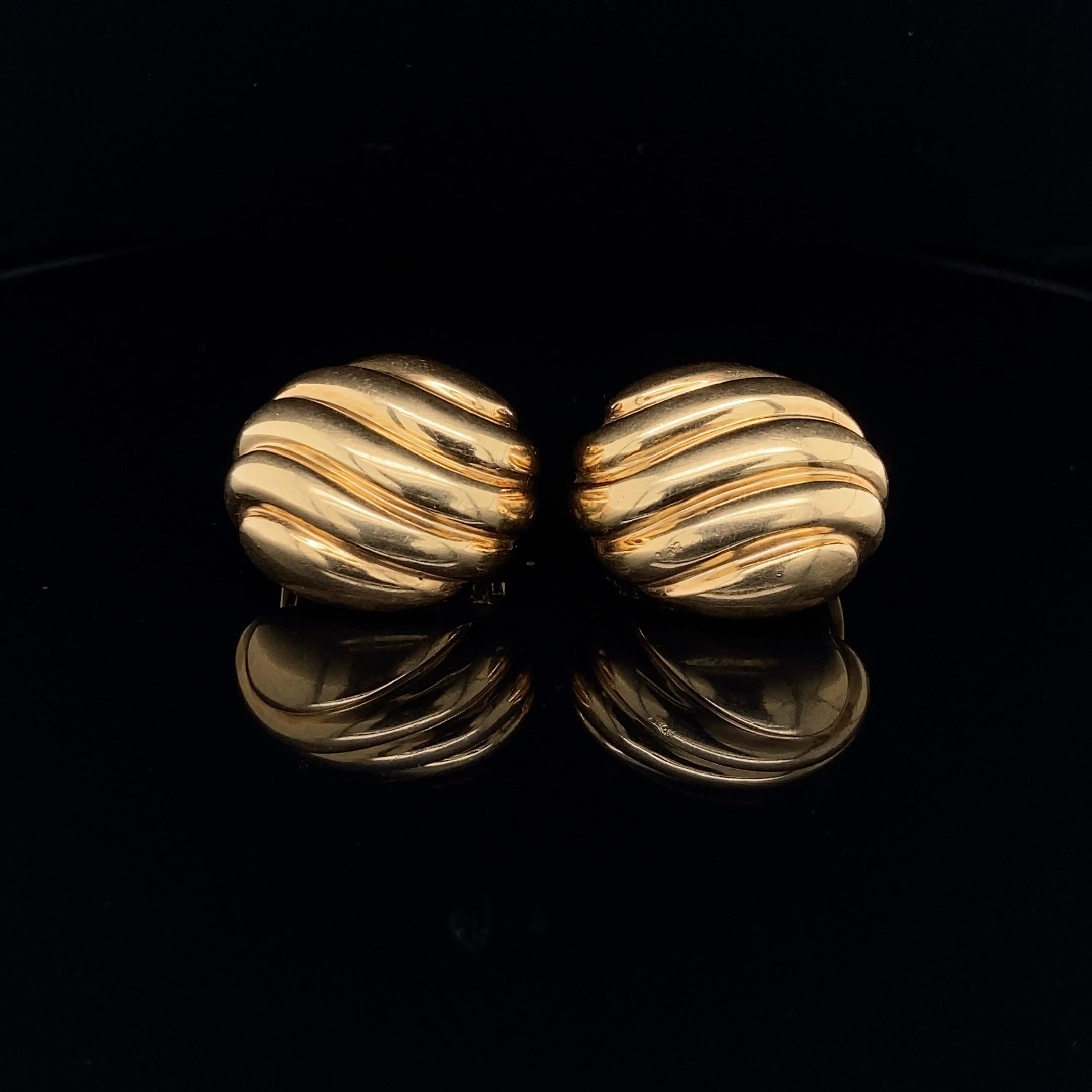 Ovale Ohrclips aus 18 Karat Gelbgold von Cartier mit einem reliefartigen Wirbelmuster. 
Die Clips haben einen schönen Vintage-Charakter, sind vollständig signiert und nummeriert Cartier 603680, gestempelt 750 und mit Französisch Assay Marke.
Länge: