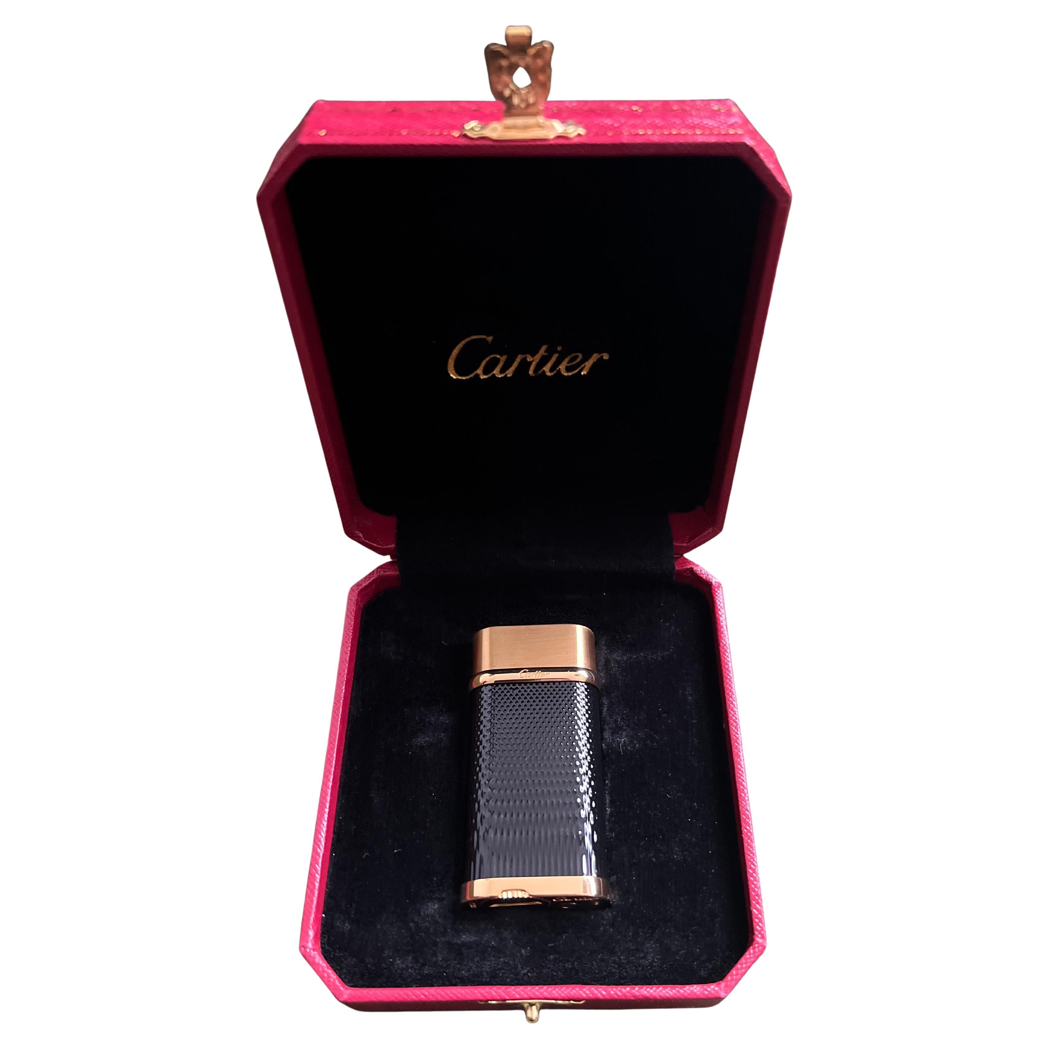 Cartier Vintage Gold Plated Black Lacquered “Cartier” Lighter In Original Case 
Circa 1990
Vintage Gold Plated Cartier lighter with Original Red luxury case, booklet, lints and outside Origial box. 
A back stock item that has never been used 
Serial