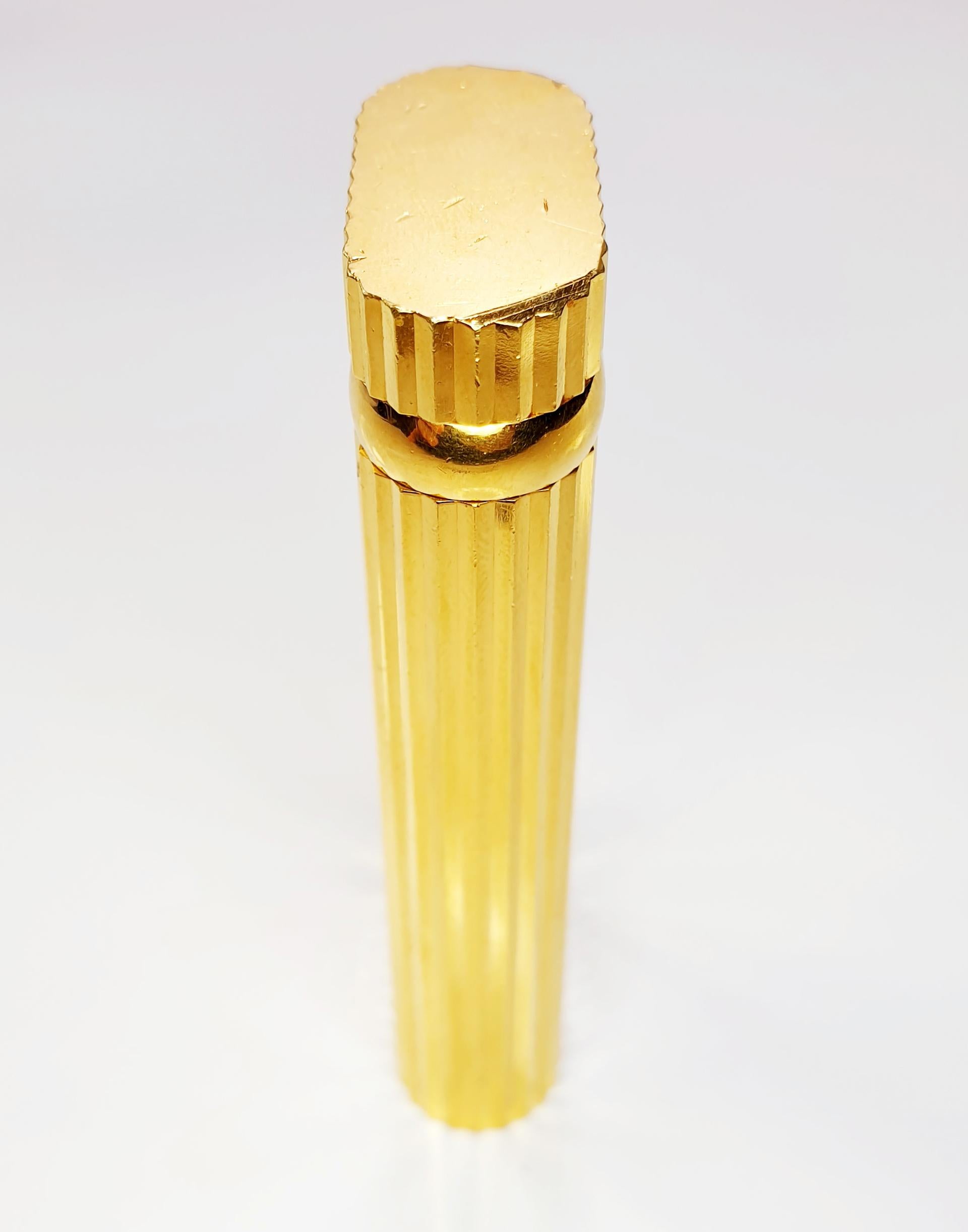 Sophisticated 'Pocket' lighter by Cartier in 18-karat gold-plated with an oval shaped body and a ribbed/fluted design. It has a flip-top lid that houses the Swiss-made mechanism. The flint wheel pivots when opened and closed as its designed to be
