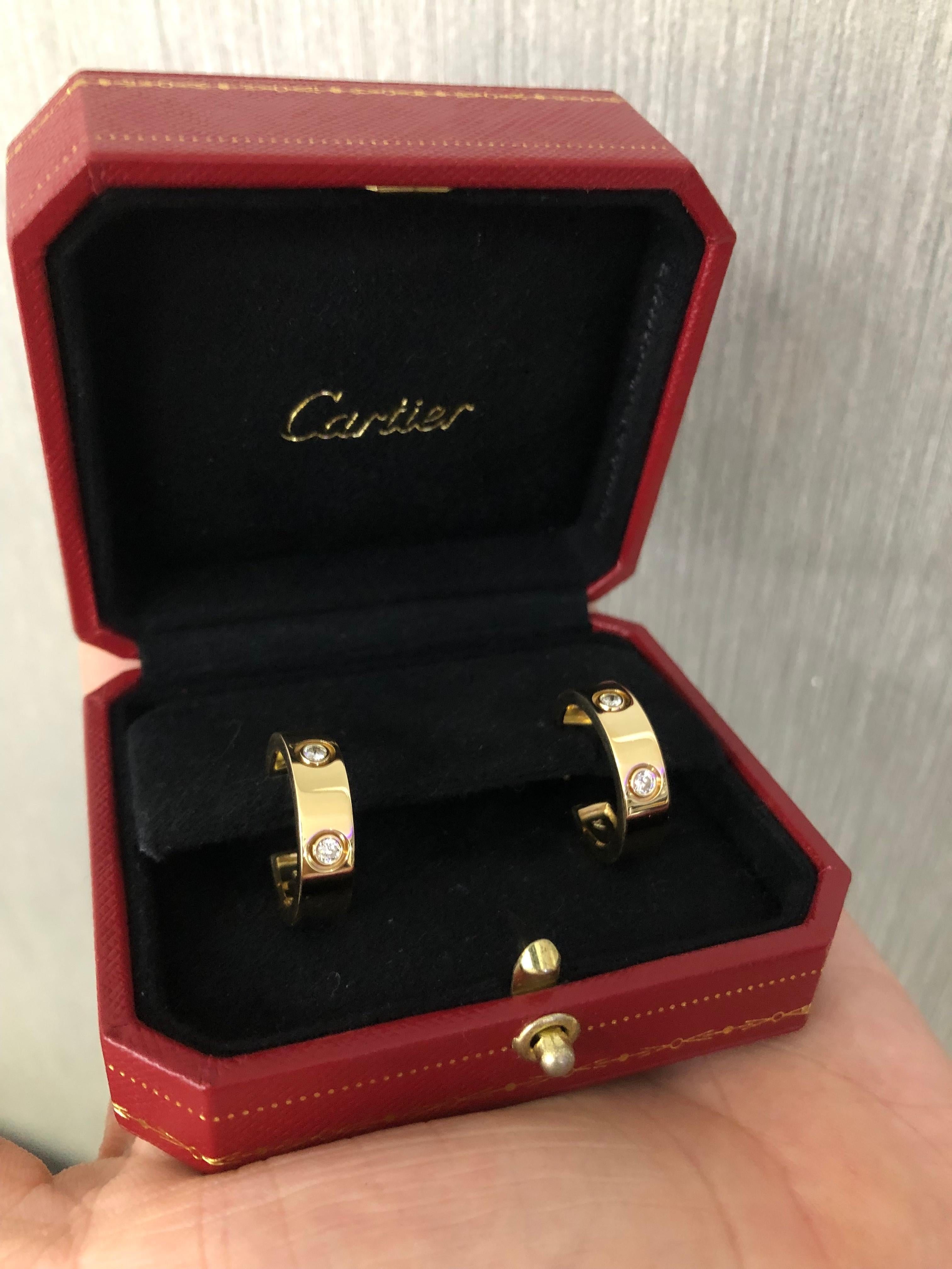 Timeless creation from famed designer Cartier. From the Love Collection these 6 Diamond hoop earrings are crafted in solid 18k yellow gold. The diamonds in the pair show F-G color and VVS1 clarity. The pair is set with approximately 0.72 carat of