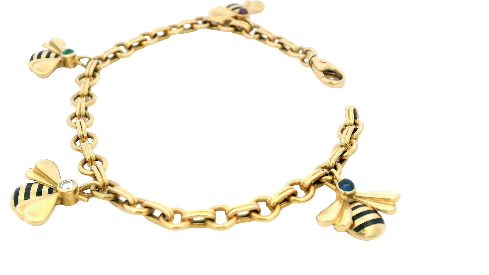 This vintage charm bracelet from Cartier is crafted from 18K yellow gold and features a delightful bee charm. It showcases 0.15 carats of round cabochon rubies, 0.15 carats of round cabochon sapphires, and 0.12 carats of round cabochon emeralds.