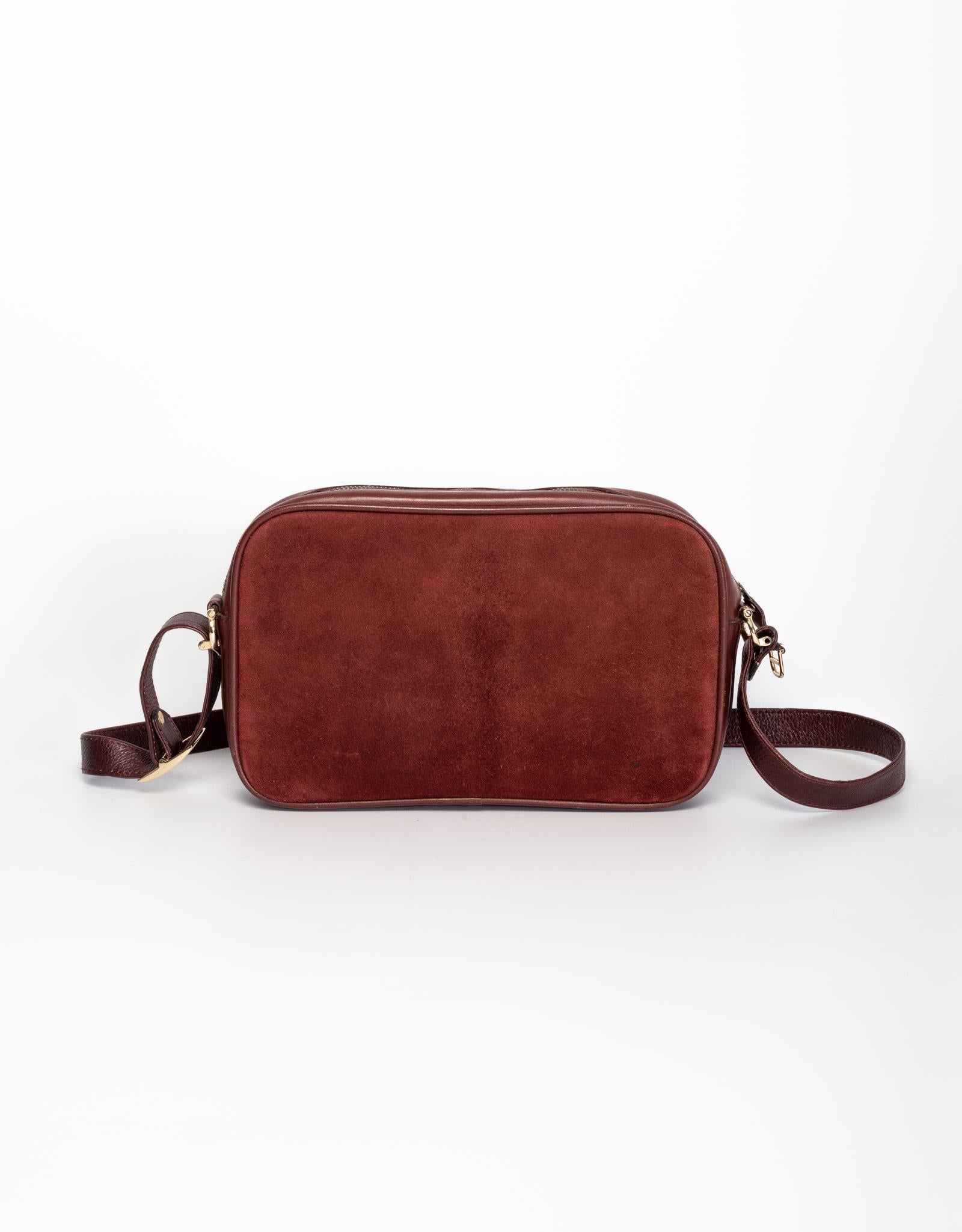 This bag is made out of suede with leather finishes and features a long strap with top zipper closure. 

COLOR: Bordeaux
MATERIAL: Suede with leather finishes
MEASURES: H 6.75” x L 10.5” x D 2.5” 
DROP: 35