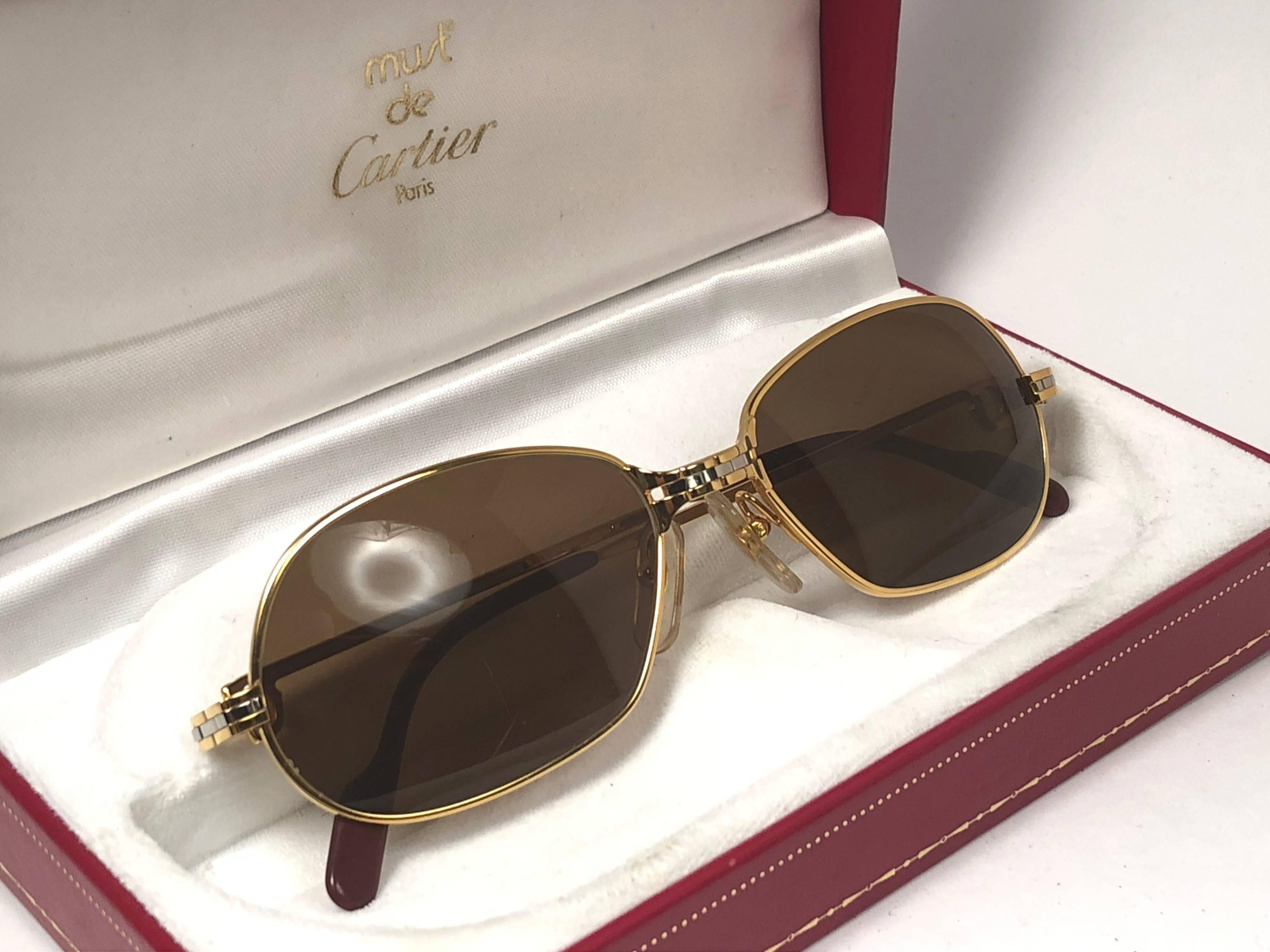 New 1988 Cartier Panthere GM sunglasses with solid brown  (uv protection) lenses.  Frame is with the front and sides in yellow and white gold. All hallmarks. burgundy ear paddles. 
Both arms sport the C from Cartier on the temple. 
These are like a