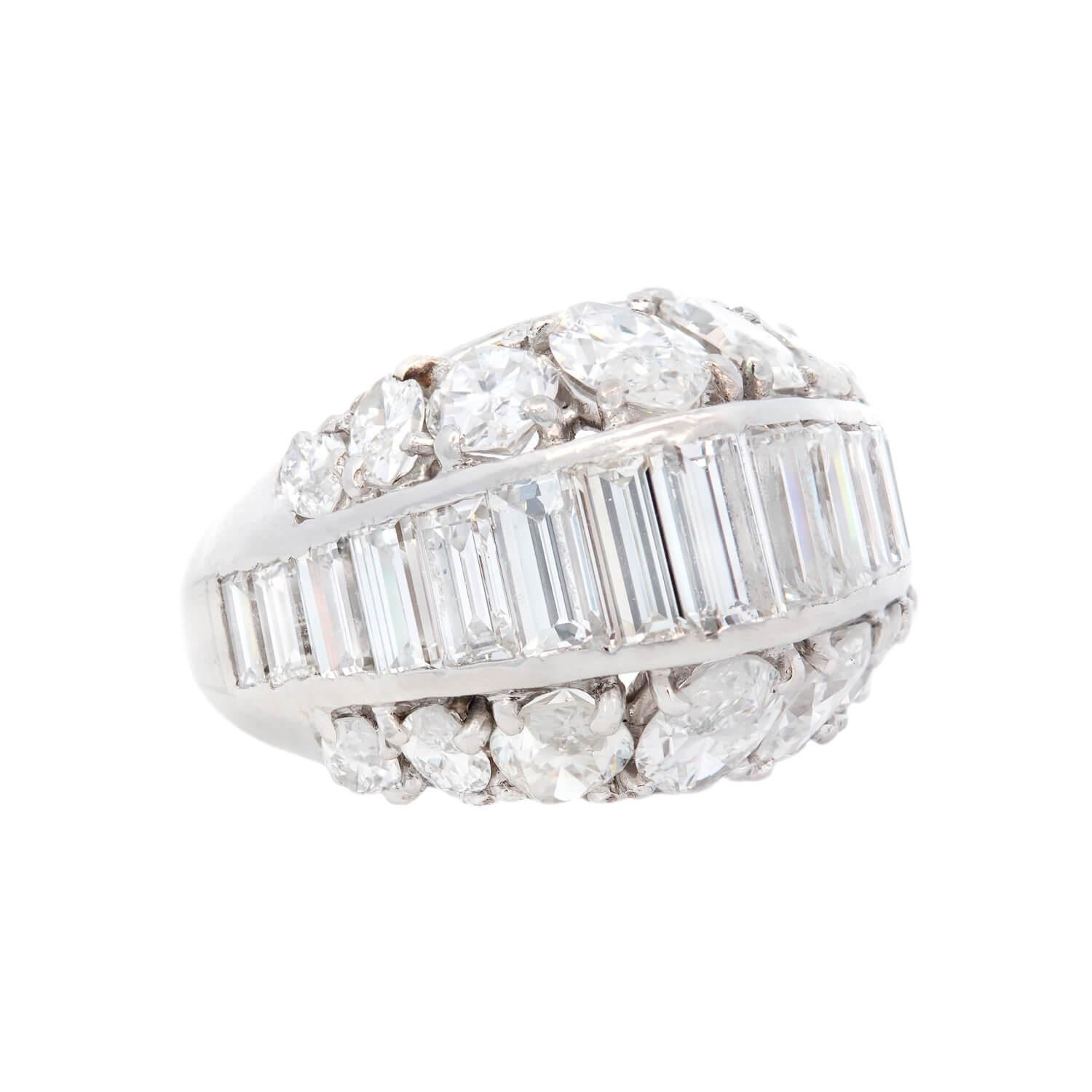 This exquisite vintage diamond ring is a signed piece by Cartier! Crafted in platinum, the centerpiece of this substantial pyramid ring is adorned with a variety of mixed cut diamonds. The center of the ring features 15 baguette diamonds, which are