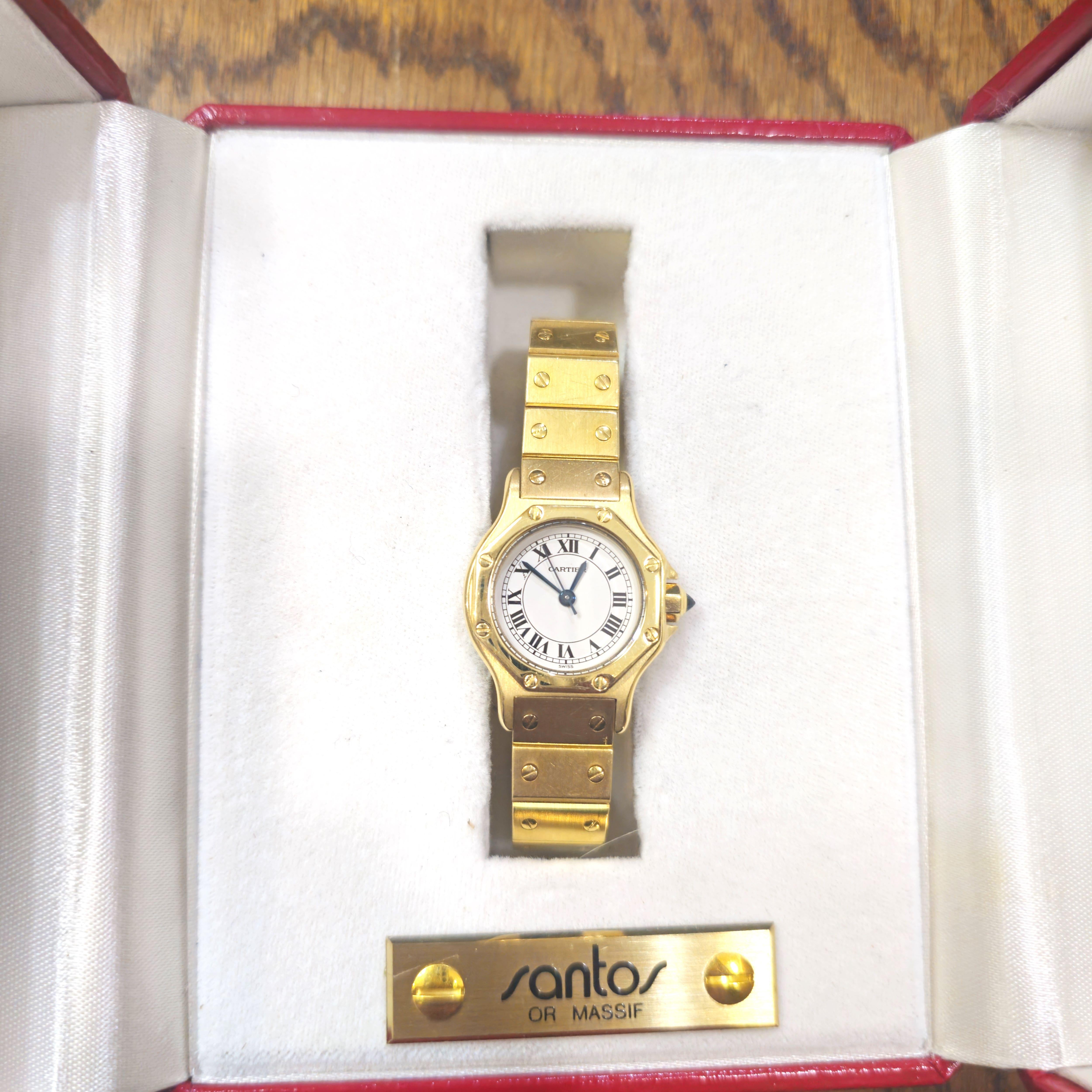 Cartier Vintage Santos achteckige runde Uhr, in 18K Gelbgold Gehäuse und Armband mit einem Durchmesser von 26mm gemacht.
Diese klassische Damenuhr ist mit einem 17-steinigen Cartier Uhrwerk mit automatischem Aufzug, weißem Zifferblatt, schwarzen