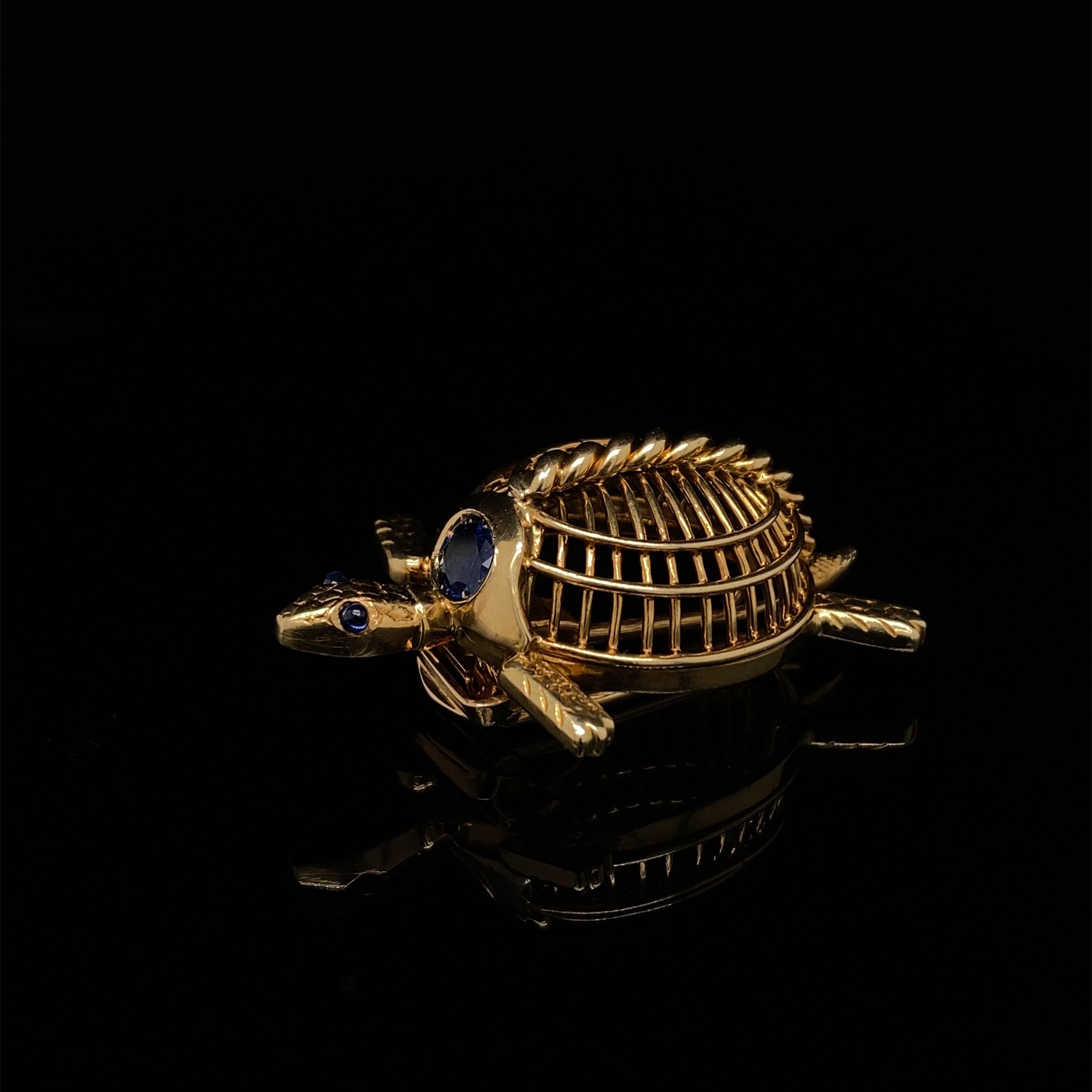 Cartier Vintage Saphir Schildkröte Brosche Brosche 18 Karat Gelbgold, um 1960.

Die Brosche stellt eine schwimmende Schildkröte mit handgravierten Beinen, Schwanz und Kopf aus Gelbgold dar. Der Schildkrötenpanzer besteht aus einem feinen, gewölbten