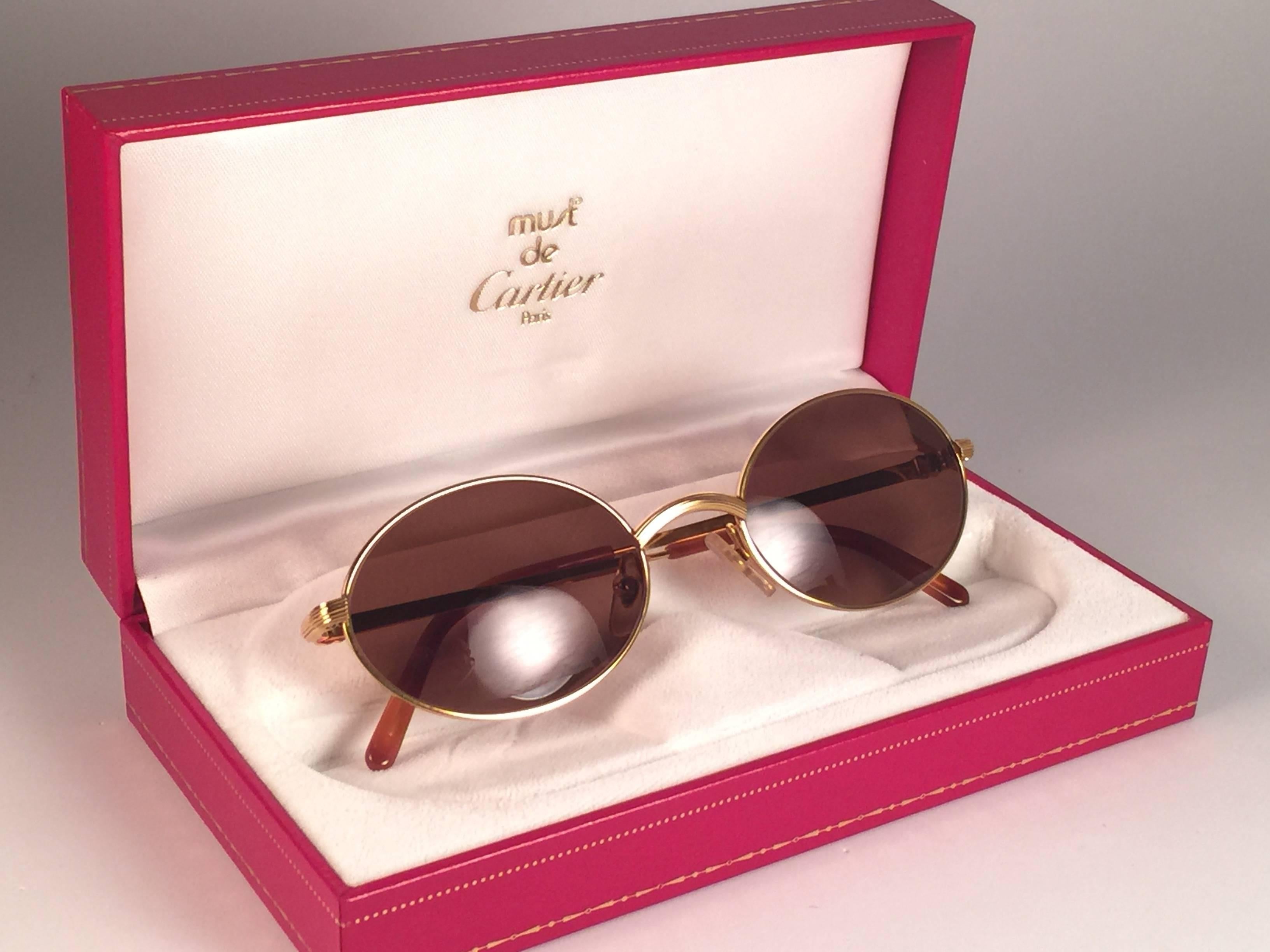 Occhiali da sole Cartier Sorbonne nuovi del 1990 con lenti marroni (protezione UV). 
Tutti i segni distintivi. 
Segni d'oro Cartier sulle palette delle orecchie. 
Sono come un paio di gioielli sul naso. Si prega di notare che questa coppia ha quasi