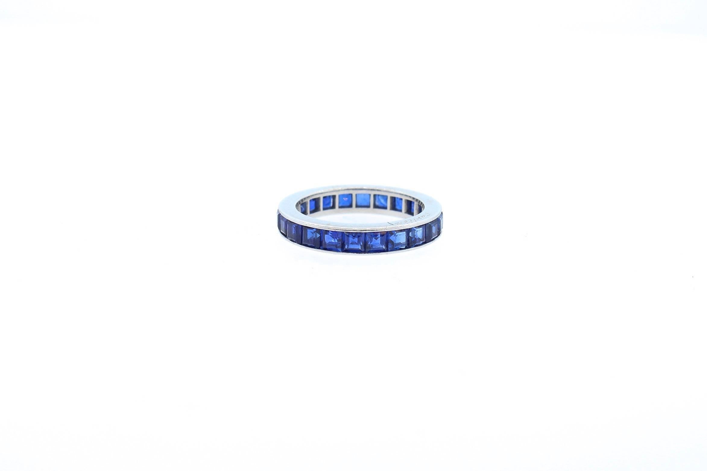 A bright blue square cut sapphire platinum wedding band made by Cartier circa 1930.  This band is set with 24 square cut sapphires that weigh approximately 3.6 carats total.  The sapphire are set in the sapphire, and has polished sides.  The band is