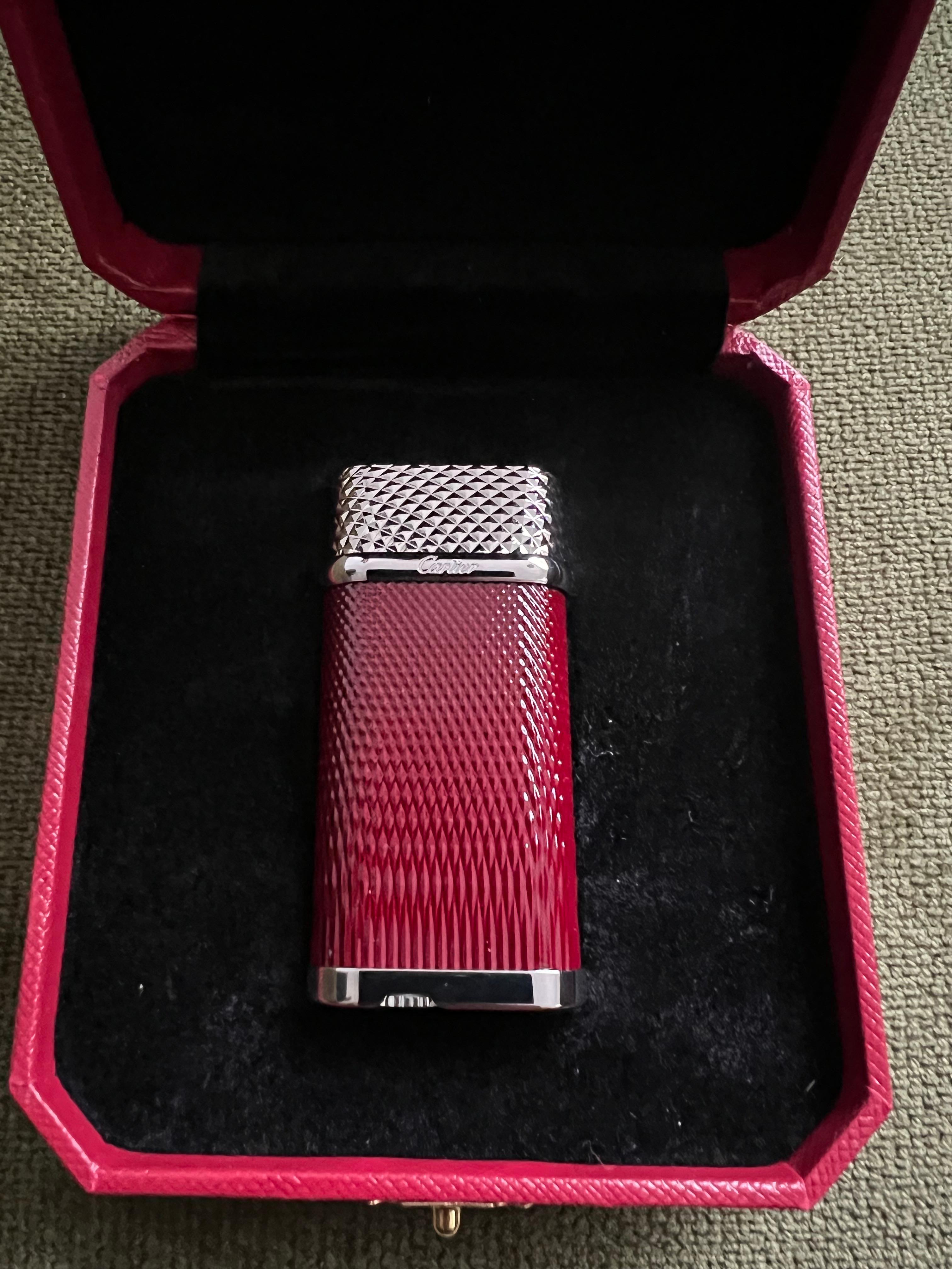 Cartier Vintage Steel & Chocolate Enamel “Cartier” Lighter In Original Case 
Circa 1990
Vintage Steel and Chocolate Enamel Plate Cartier lighter with Original Red luxury case, booklet, lints and outside Original box. 
It does not look it has been