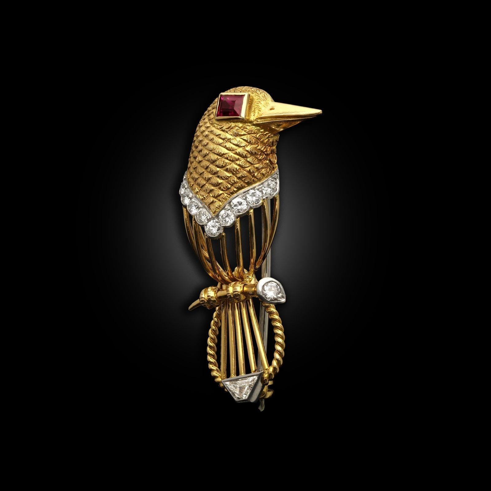 A vintage stylised bird brooch by Cartier circa 1960s. The bird is designed in 18ct yellow gold with a textured feather pattern on the head, an open gold wire body with a rope twist on the tail. The bird has round brilliant cut diamond details set