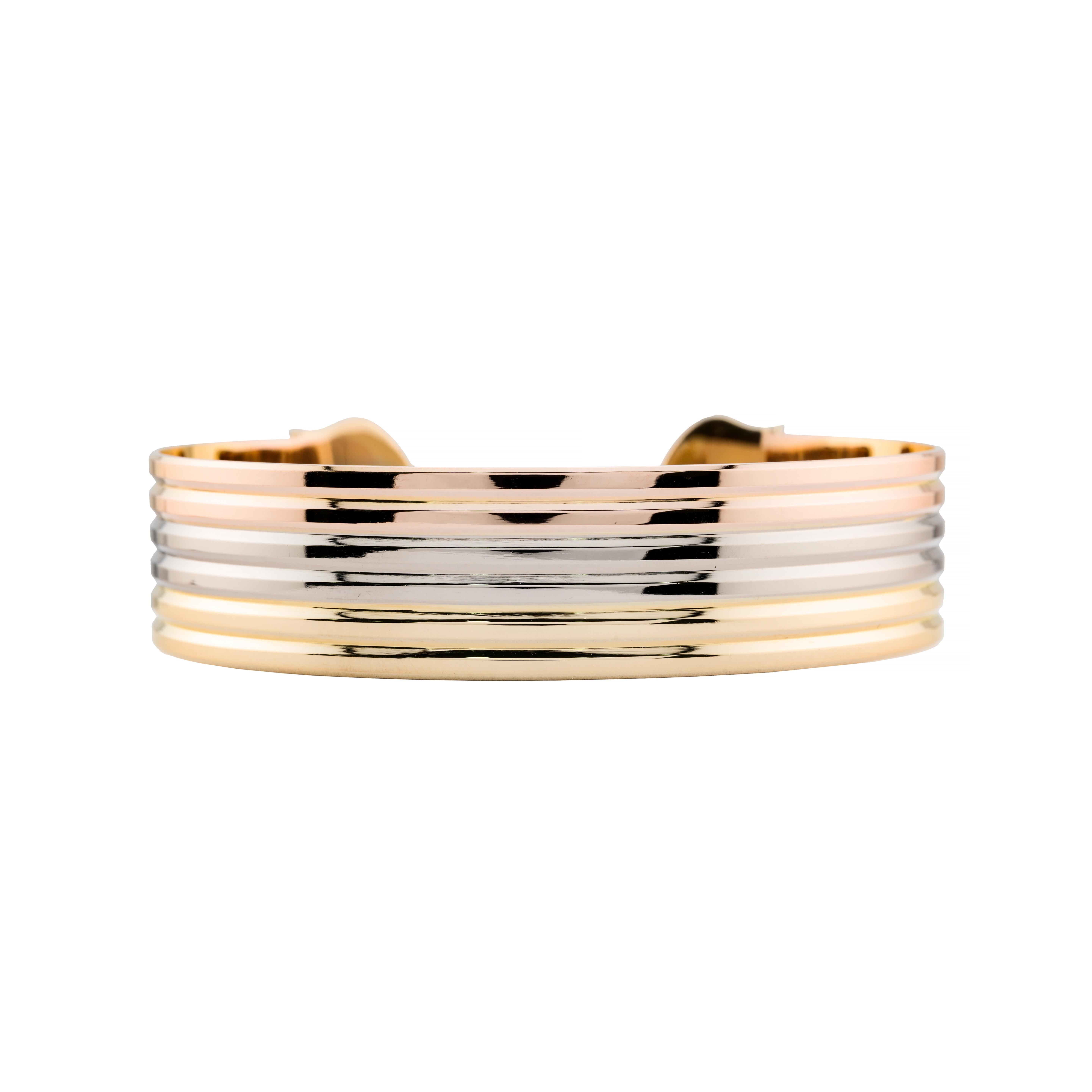 Aston Estate Jewelry stellt vor:

Ein Cartier-Armband im Retro-Stil aus 18 Karat Gold. Die schlichte, offene Manschette ist mit abwechselnden Bändern aus Rosé-, Weiß- und Gelbgold gestaltet. Die glatte, polierte Oberfläche unterstreicht die elegante