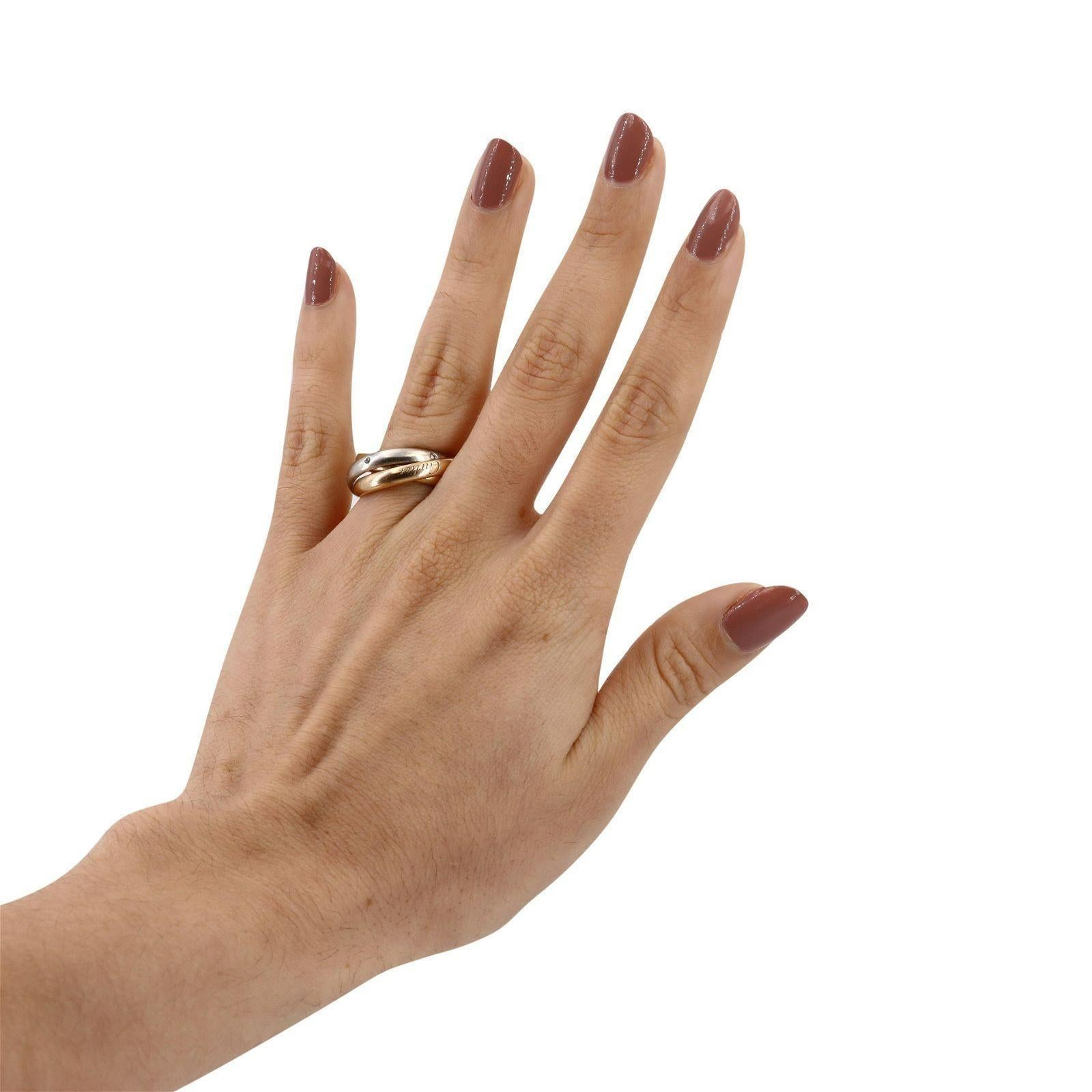 La bague trinitaire vintage de Cartier datant des années 1990 est un symbole iconique d'élégance et de signification intemporelles. Réalisée en or tricolore 18 carats, cette pièce présente des bandes d'or rose, jaune et blanc entrelacées, chacune