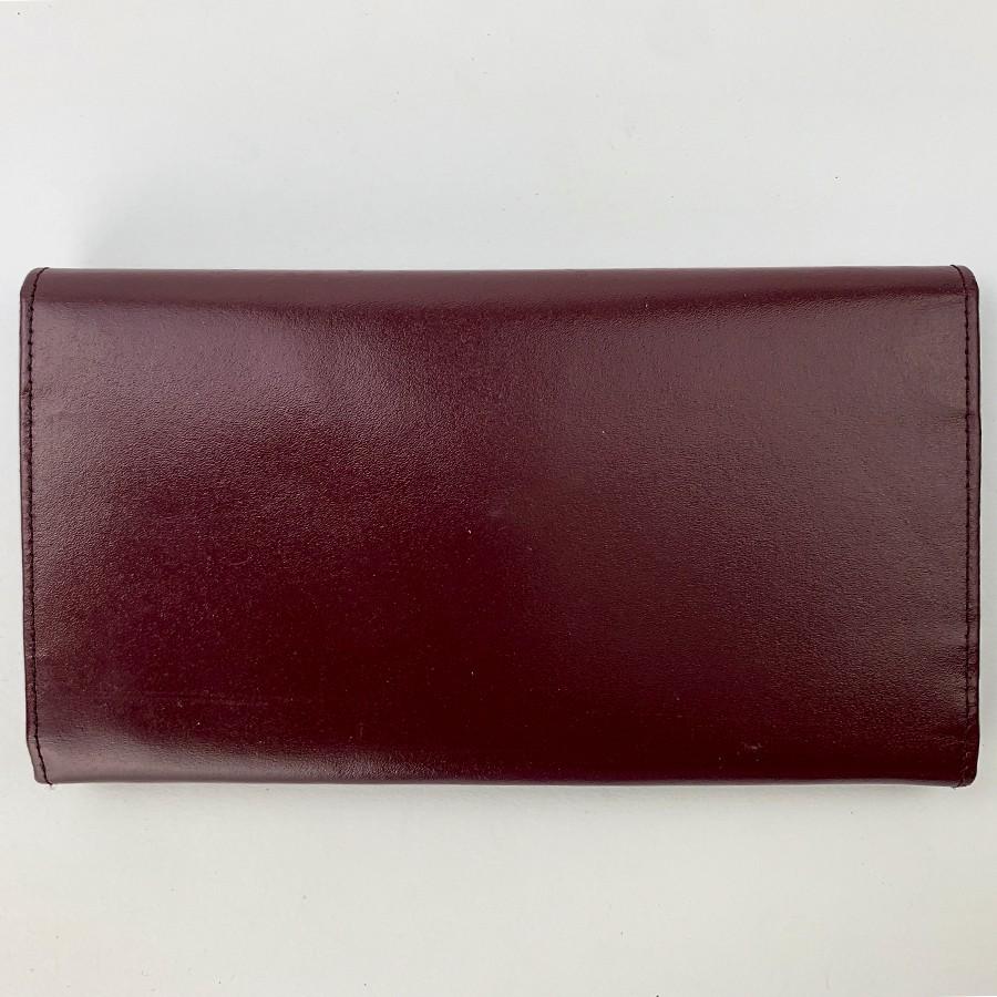 CARTIER Wallet in Burgundy Leather. It is rectangular shape in embossed burgundy leather with the double C of the brand. 
Its clasp is a snap button and its finishes are in gilt metal. 3 compartments for your cards as well as 3 compartments for