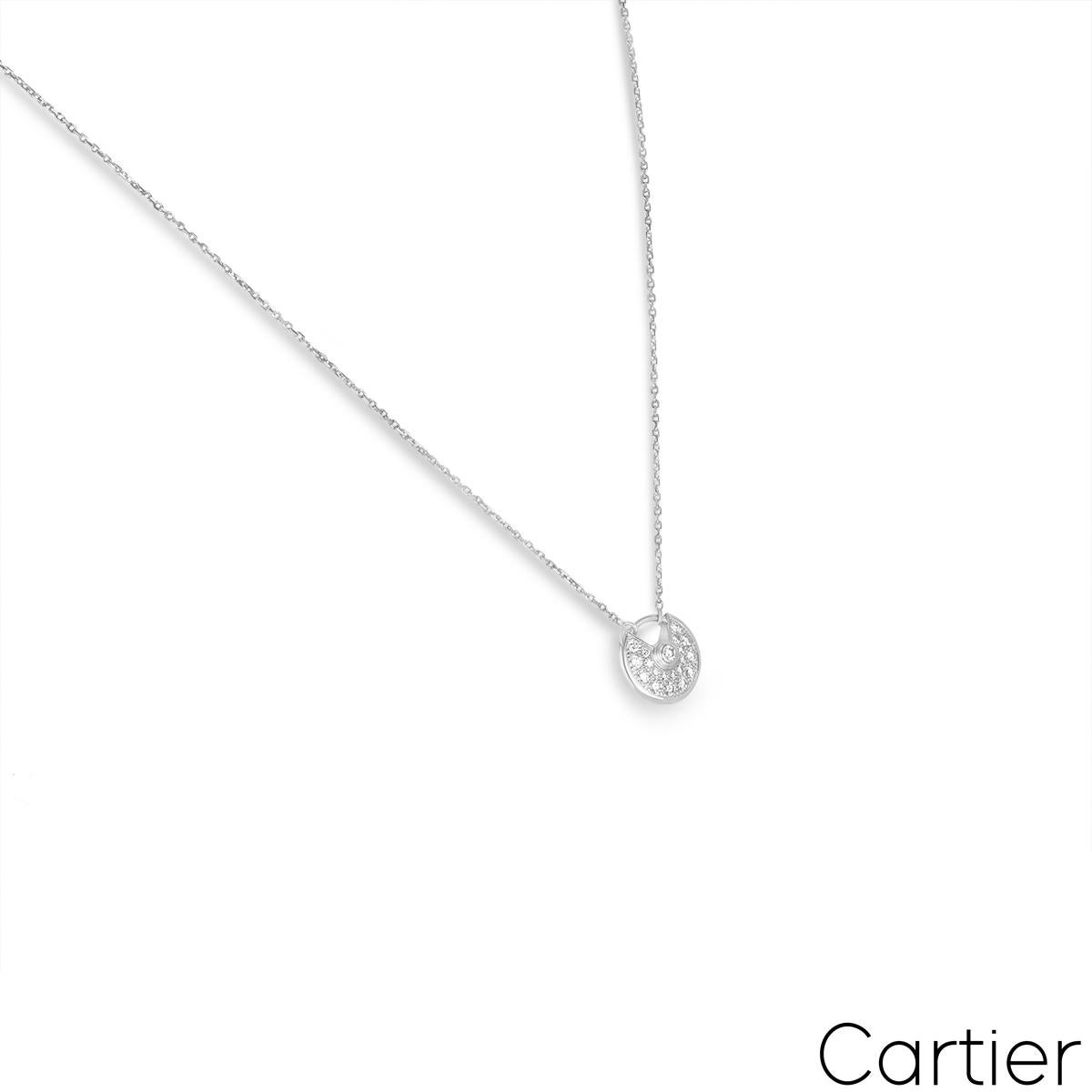 Uno splendido pendente Cartier in oro bianco 18 carati con diamanti della collezione Amulette de Cartier. Il motivo circolare del talismano ha un singolo diamante rotondo taglio brillante incastonato al centro e 19 diamanti rotondi taglio brillante