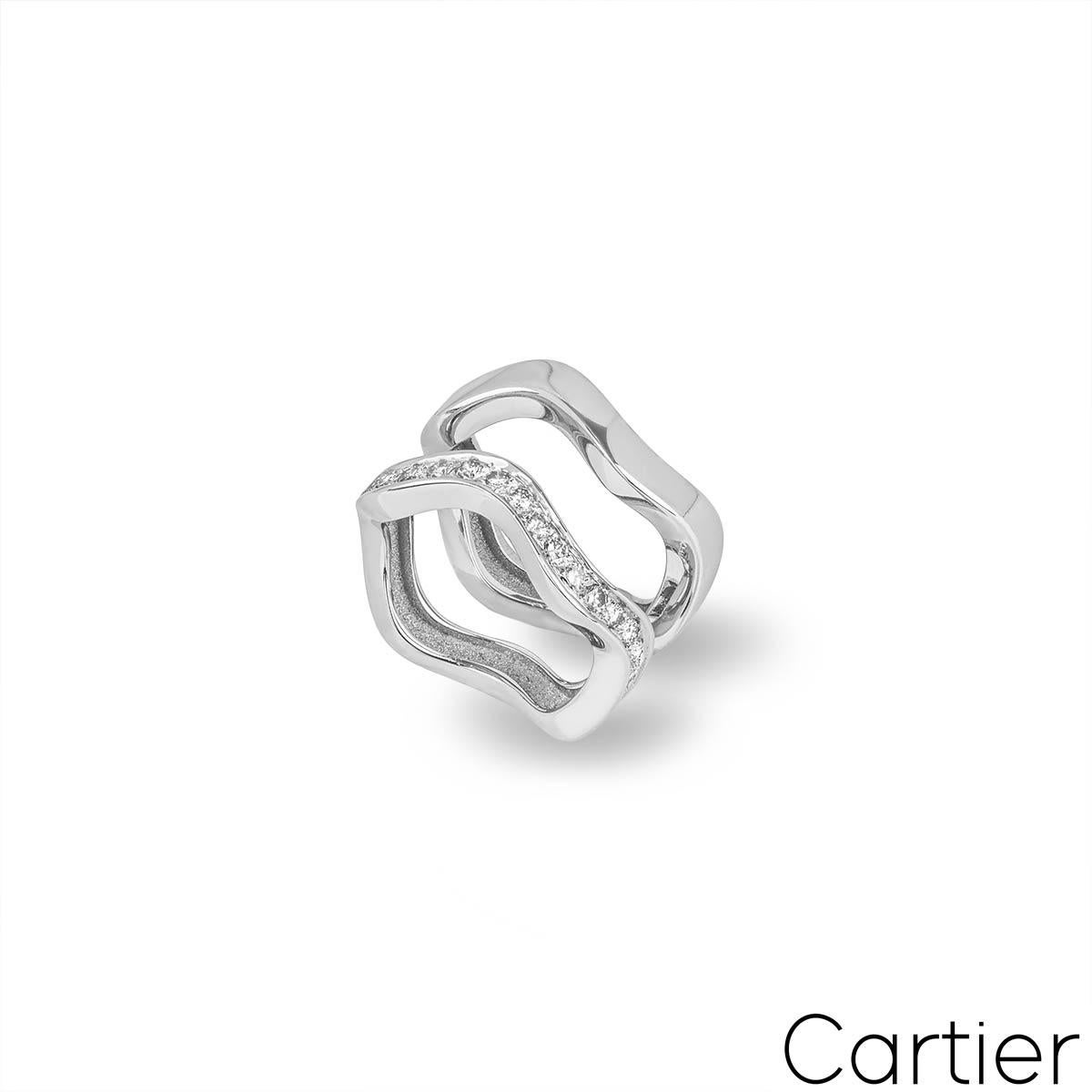 A beautiful 18k white gold double stacker ring by Cartier. The ring is composed of 2 waved bands. One band is pave set with 19 round brilliant cut diamonds totalling approximately 0.57ct, predominantly F in colour and VS-VVS in clarity. Each ring