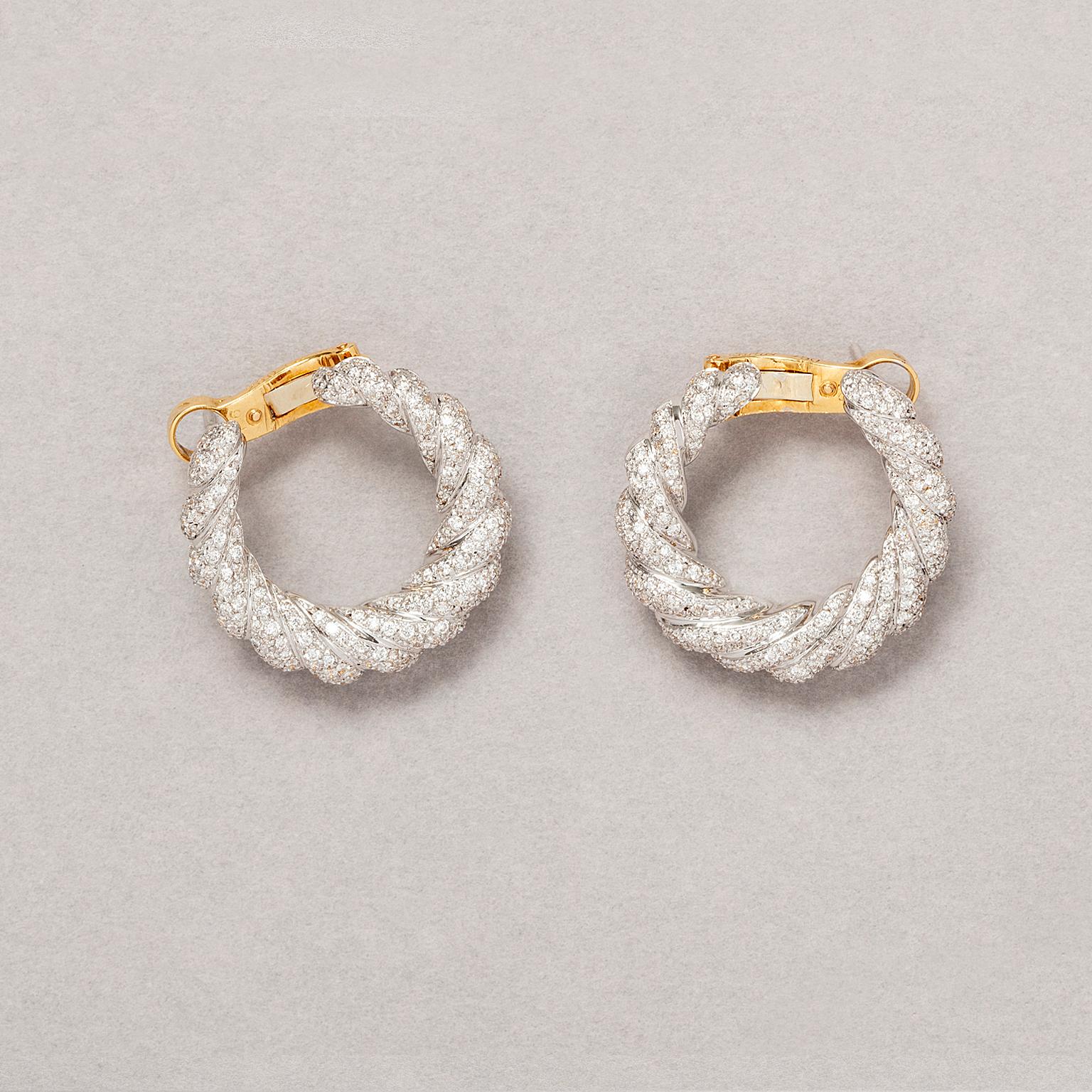 A pair of 18 carat white and yellow gold earrings. White gold twisted, garland like hoops, set with 430 brilliant cut diamonds (in total app. 2.5 carat G-H, Si). Signed and numbered: Cartier, 608592, with the original box.

weight: 16.10