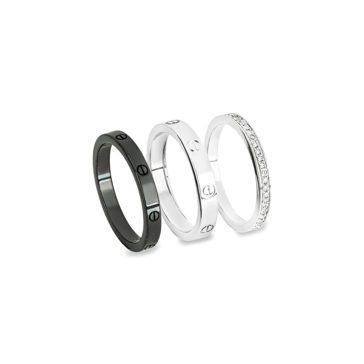 An 18k white gold, ceramic and diamond set of three bands by Cartier from their Love collection. The set includes a plain ceramic Love ring measuring 2.6mm in width, a plain white gold Love ring measuring 3mm in width, and a white gold Love ring
