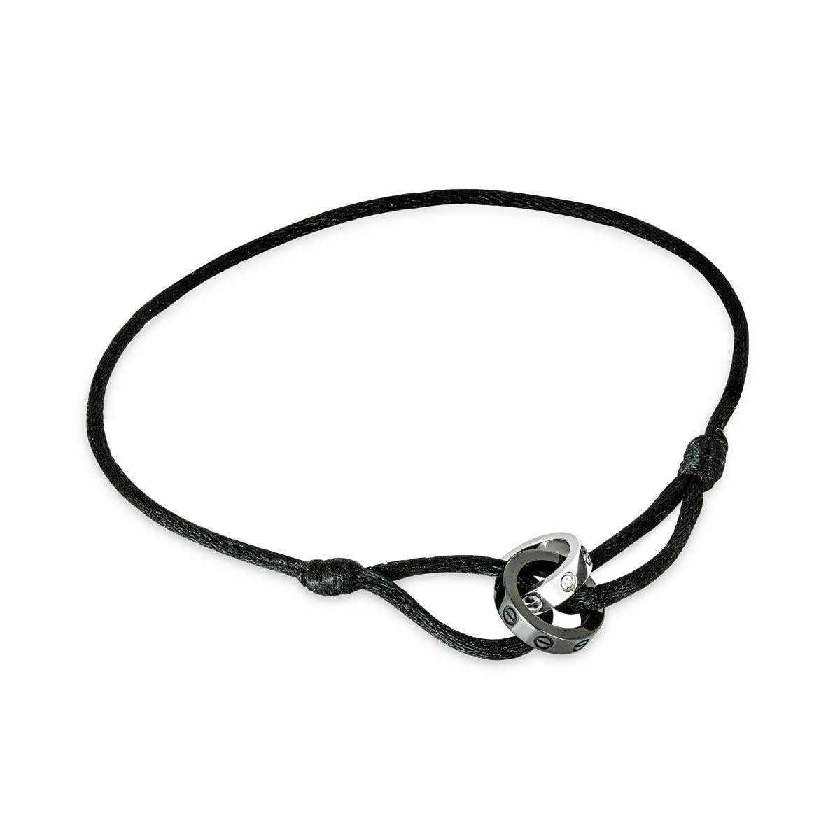 Un élégant bracelet en or blanc 18 carats et céramique de Cartier de la collection Love. Le bracelet se compose de deux motifs circulaires imbriqués, arborant le motif iconique de la vis, l'un en céramique noire et l'autre en or blanc serti de 4
