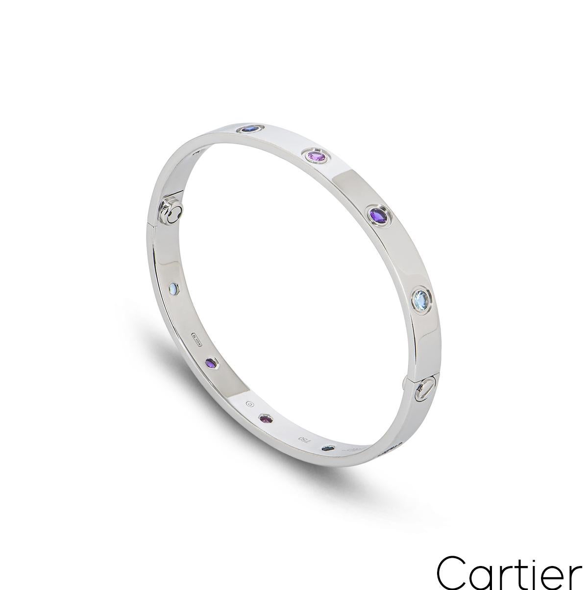 An 18k white gold coloured stones Cartier bracelet from the Love collection. The bracelet is set with 10 coloured stones throughout the centre, including purple spinel, blue and pink sapphires, amethyst and aquamarine. The bangle has the new style