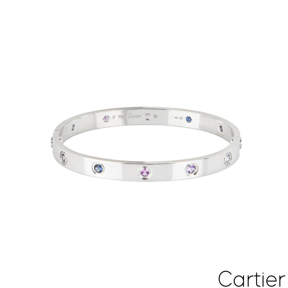 An iconic 18k white gold coloured stones Cartier bracelet from the Love collection. The bracelet is set with 10 coloured stones throughout the centre, including purple spinel, blue and pink sapphires, amethyst and aquamarine. The bangle has the old