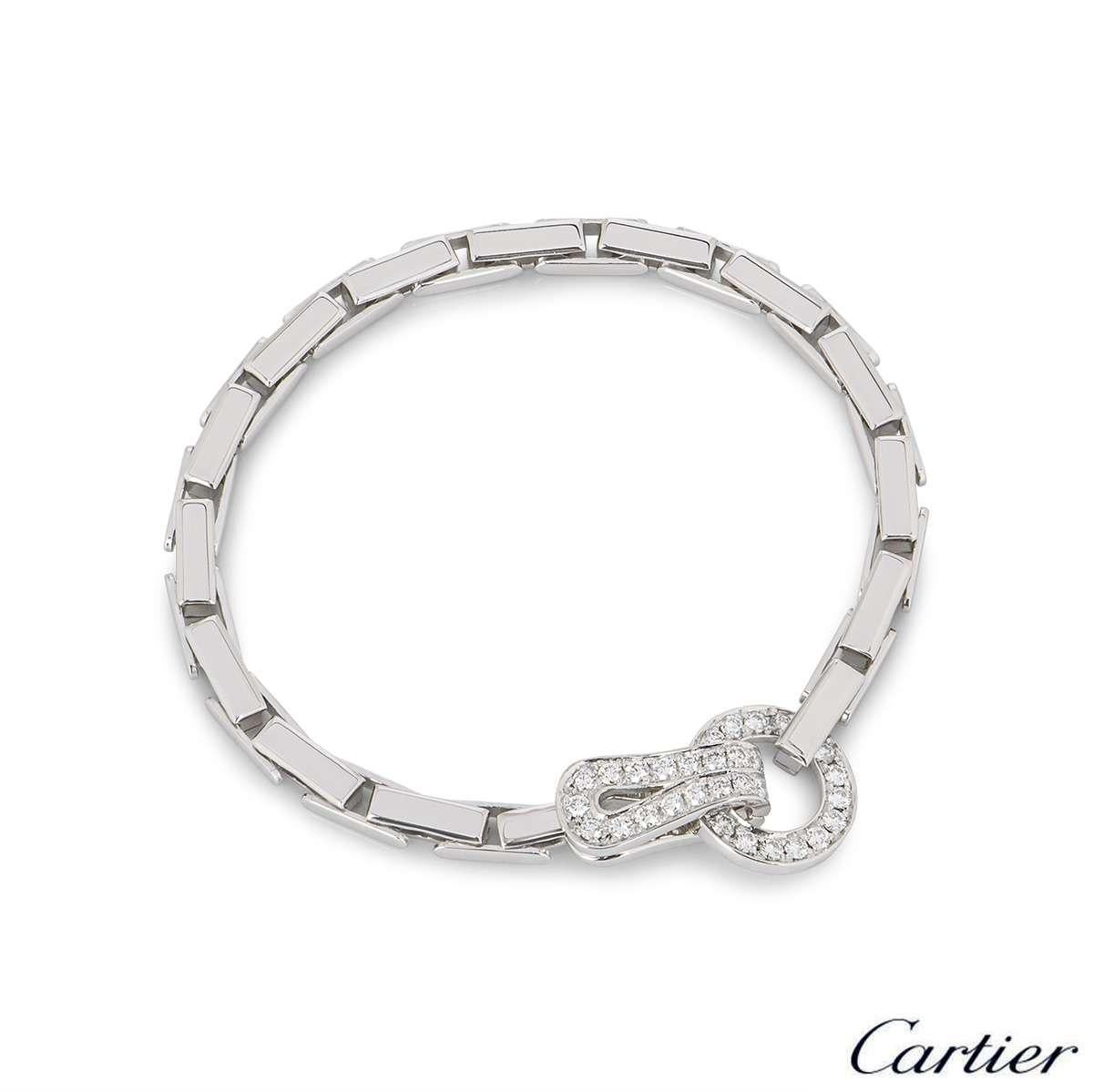 An 18k white gold bracelet by Cartier from the Agrafe collection. The bracelet features the classic openwork Agrafe diamond set motif connected by brick style links. There are 35 round brilliant cut diamonds with a total weight of approximately