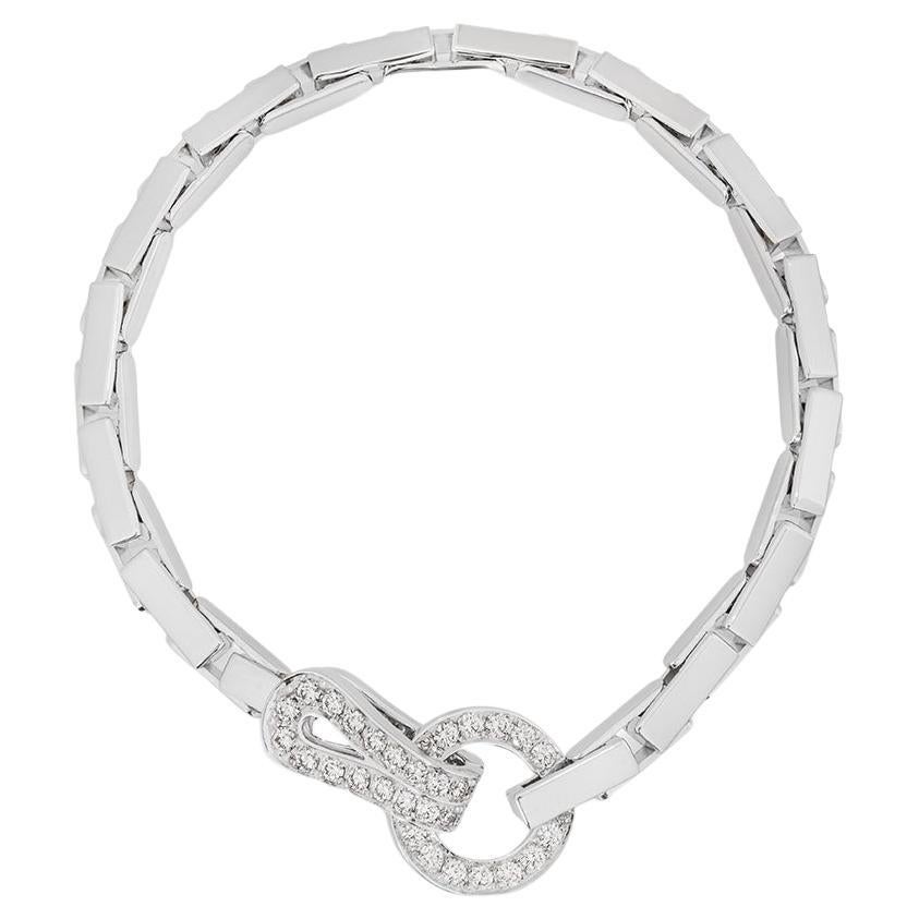 An alluring 18k white gold diamond bracelet by Cartier from the Agrafe collection. The bracelet features the classic openwork Agrafe diamond set motif connected by brick style links. There are 35 round brilliant cut diamonds with a total weight of