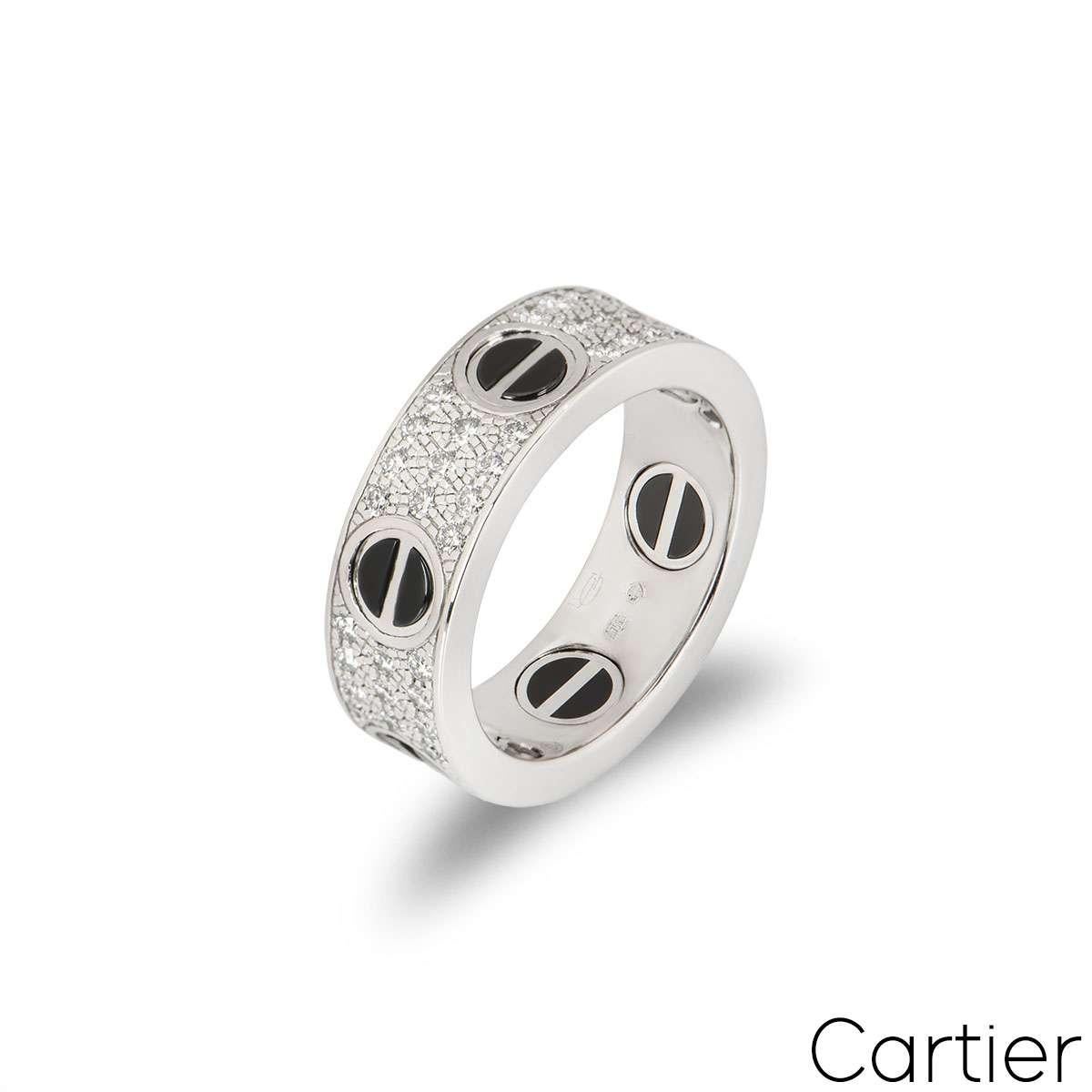 An 18k white gold diamond set Love ring by Cartier. The ring features the classic screw motif, featuring a ceramic inlay, around the outer edge and has 66 pave set, round brilliant cut diamonds set between each screw, totalling 0.74ct. The 6.5mm