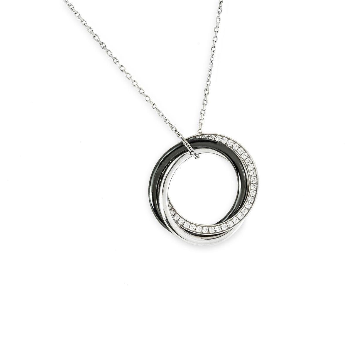 An 18k white gold Cartier diamond and ceramic necklace from the Trinity de Cartier collection. The pendant features triple interlaced rings, two in white gold and one black ceramic, one white gold ring has 44 round brilliant cut diamonds totalling