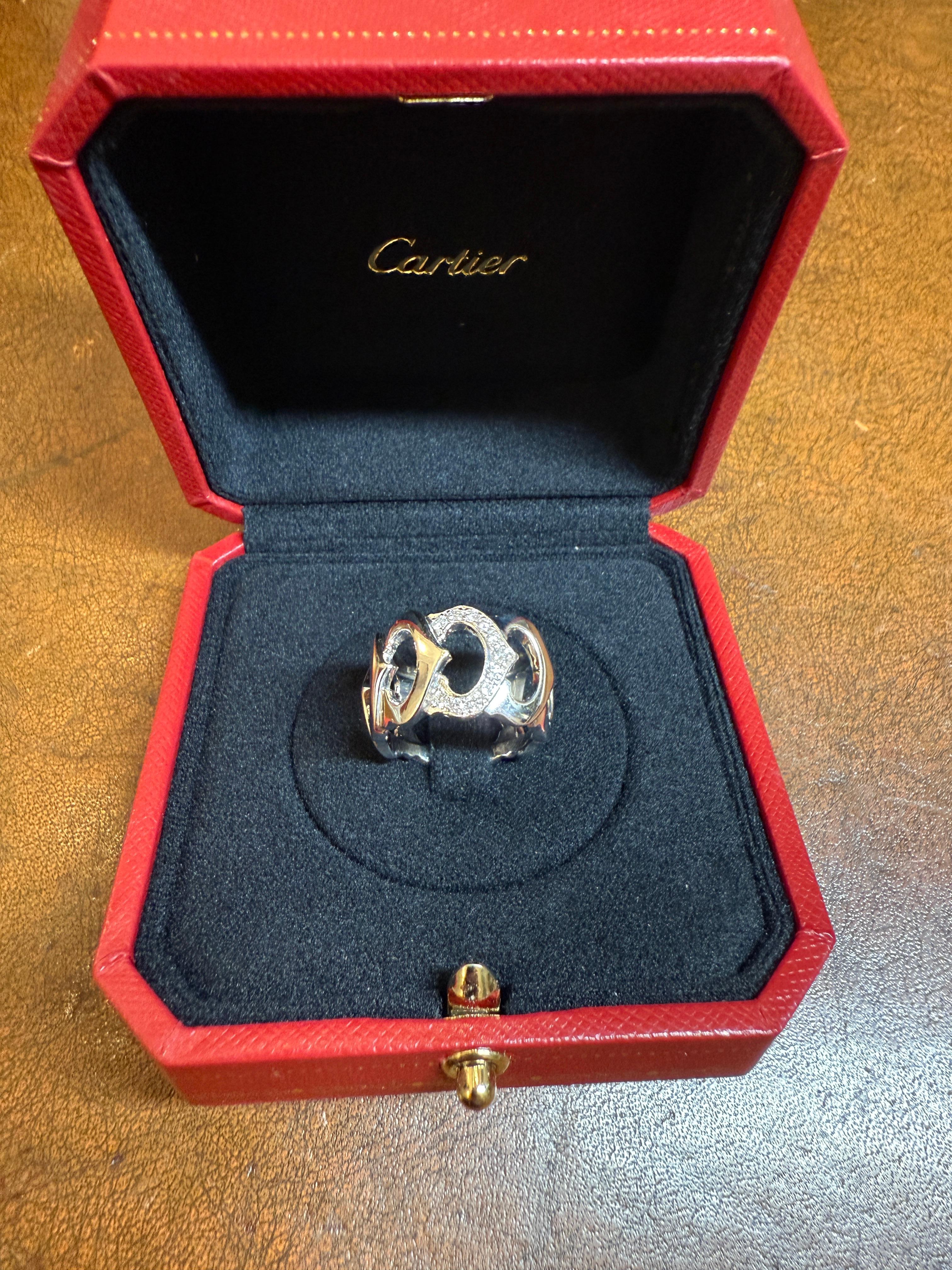 A beautiful vintage 18k white gold ring by Cartier from the C de Cartier collection. The openwork ring features 9 interlocking iconic C motifs, one pave set with 11 round brilliant cut diamonds totalling approximately 0.25ct. The ring measures size