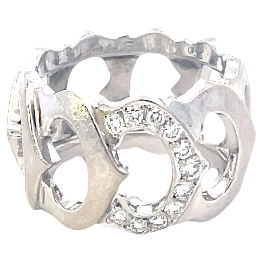 A beautiful vintage 18k white gold ring by Cartier from the C de Cartier collection. The openwork ring features 9 interlocking iconic C motifs, one pave set with 11 round brilliant cut diamonds totalling approximately 0.25ct. The ring measures size