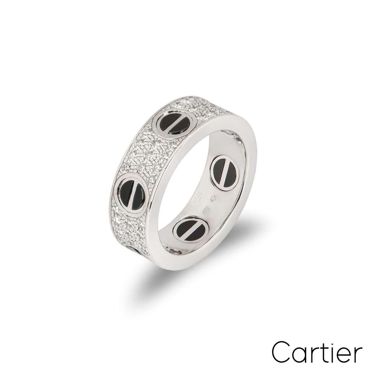 An 18k white gold diamond set Love ring by Cartier. The ring features the classic screws featuring a ceramic inlay and has 66 pave set, round brilliant cut diamonds set between each screw, totalling 0.74ct. The 6.5mm wide ring is a UK size N/ US
